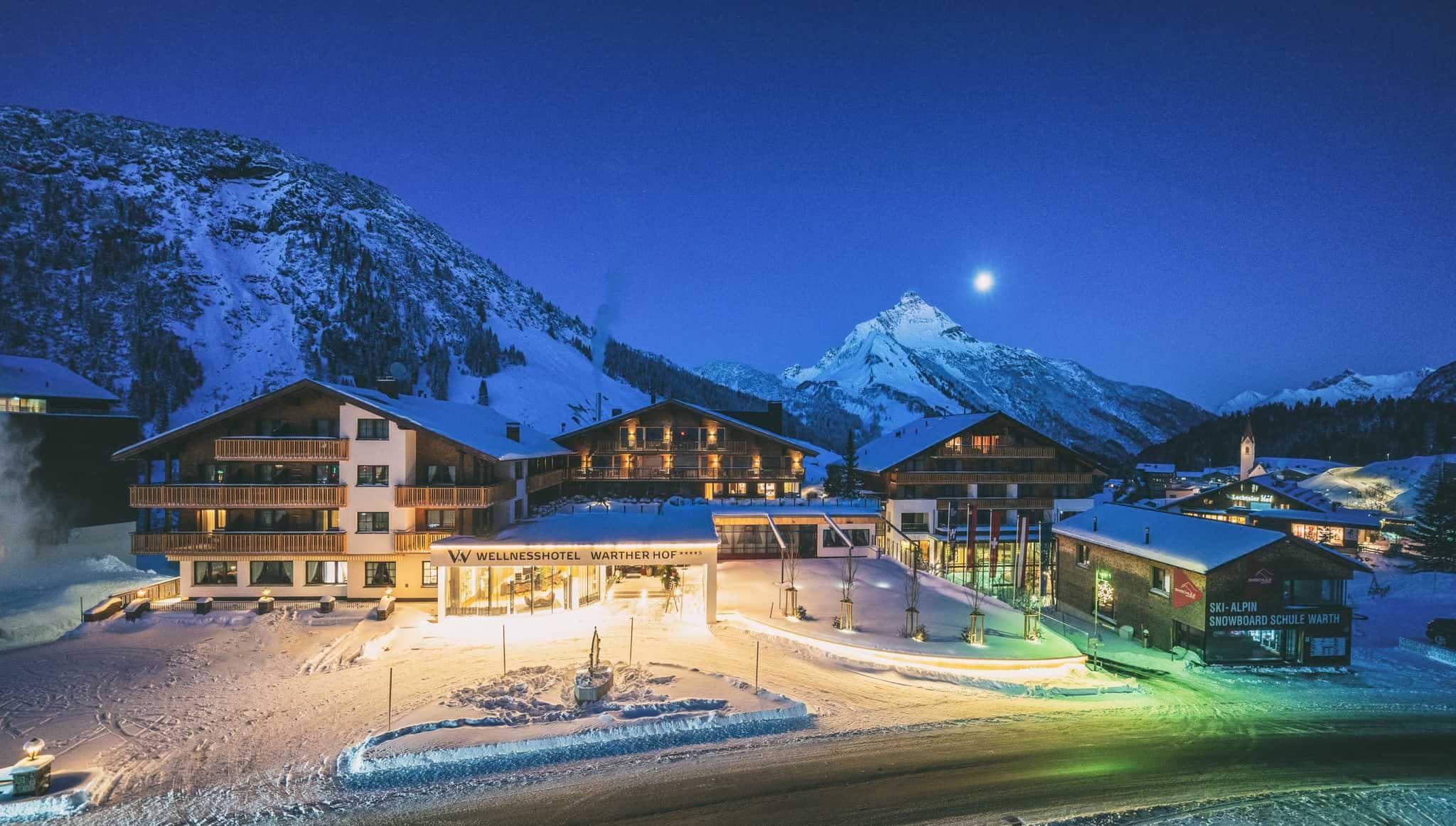 Ski-in/ski-out hotel exterior located directly adjacent to Warth snowboard school