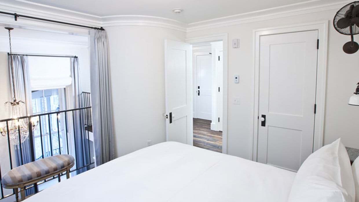 Loft bedroom overlooking living area with reach-in closet