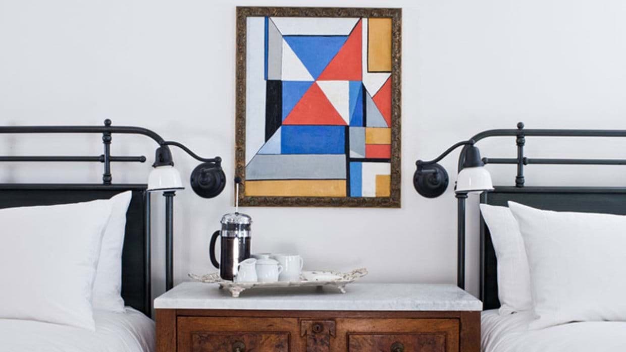 Guest bedroom with two twin beds and individual wall-mounted reading lights