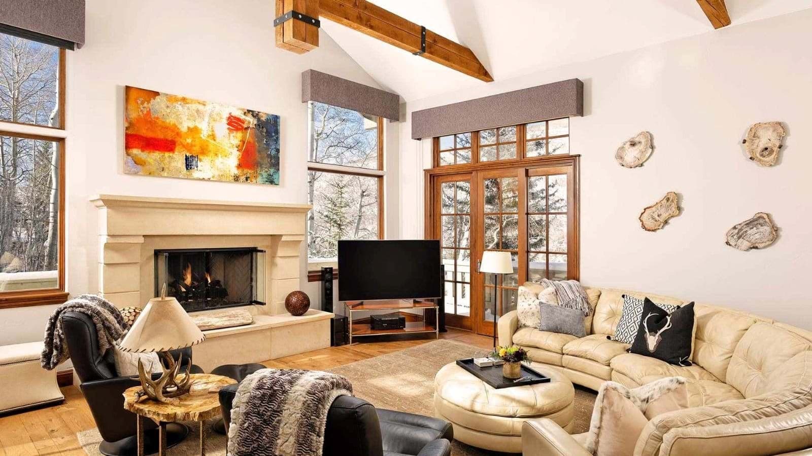 Living room with wood-burning fireplace and vaulted ceilings; deck access