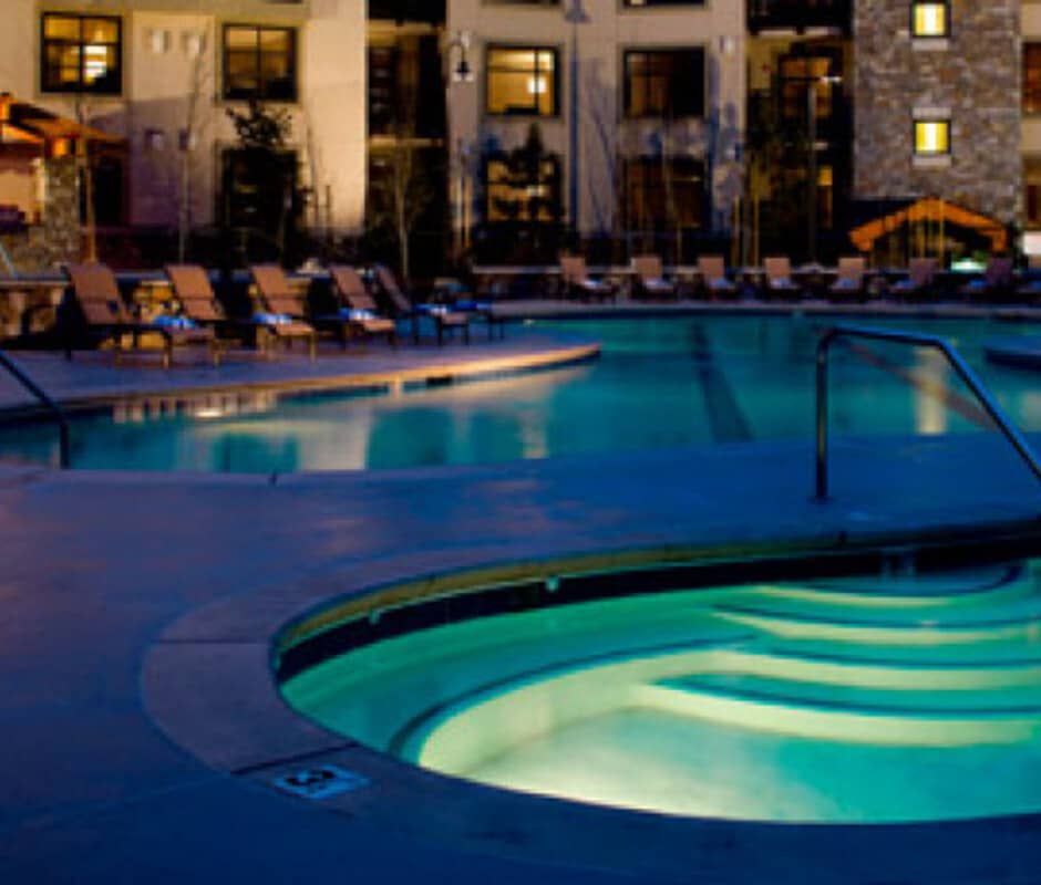 Shared outdoor heated pool and hot tub with lounge seating