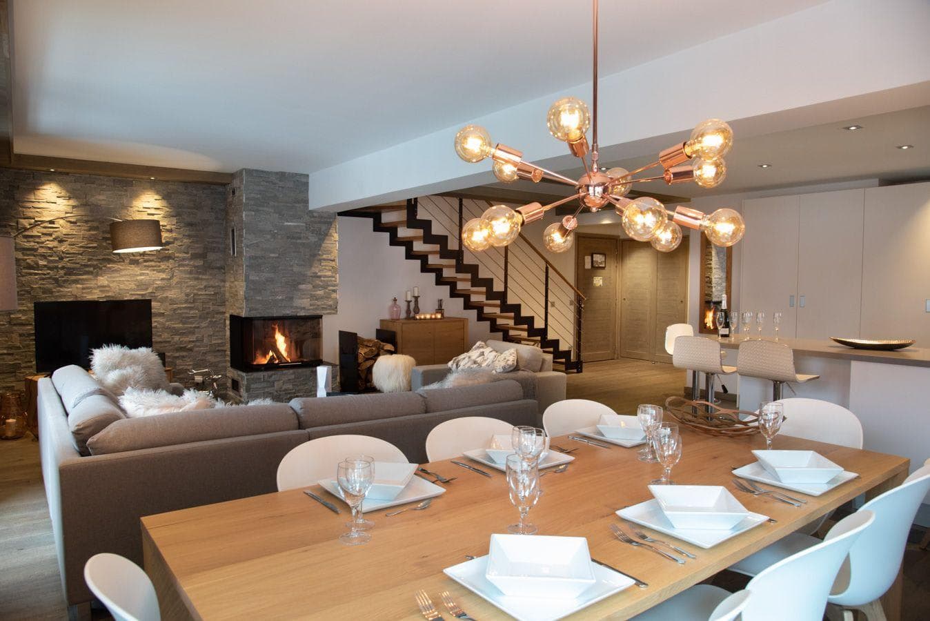 Open-plan living area with 10-person dining table and wood-burning fireplace