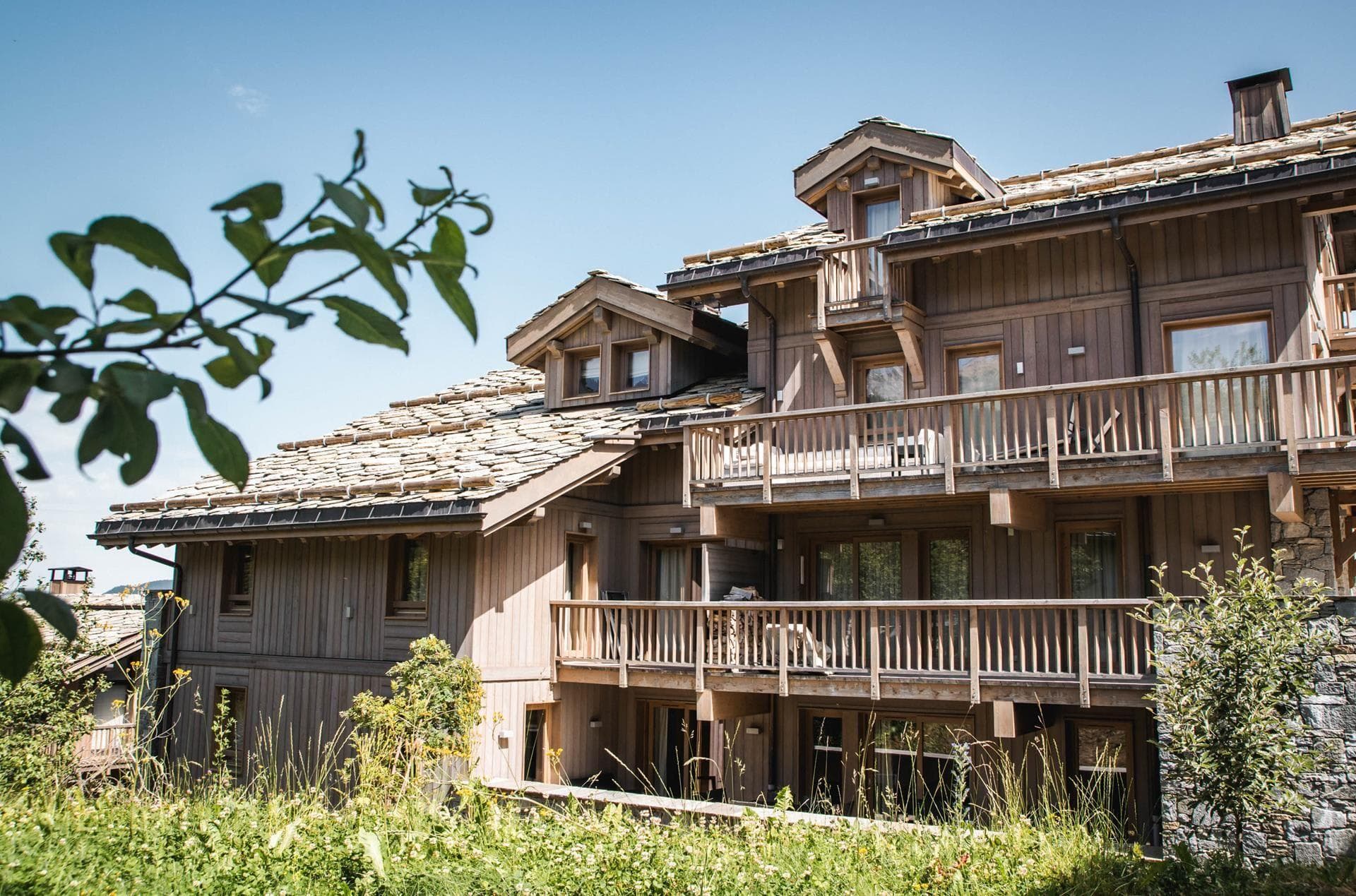 Timber chalet exterior with tiered balconies and traditional stone-slate roof