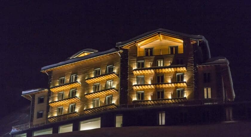 Ski-in/ski-out lodge exterior with private balconies and illuminated timber facade