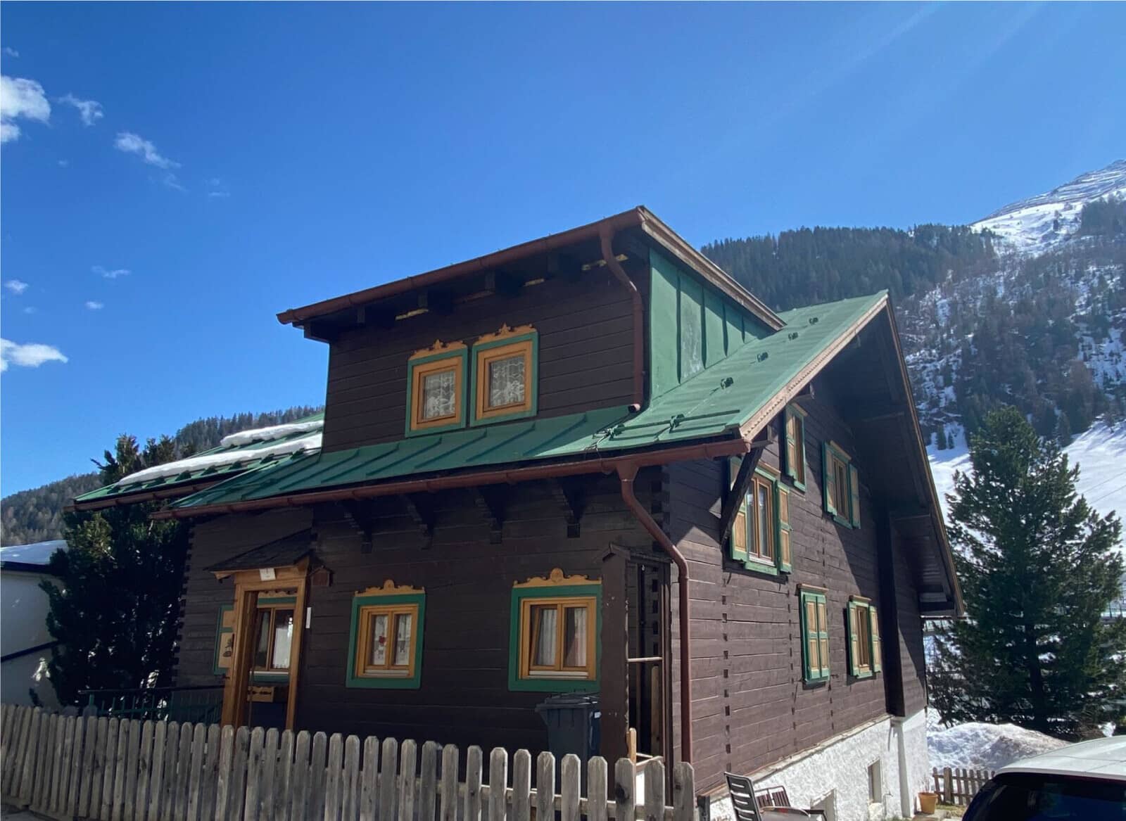 Traditional timber chalet exterior with mountain views and wood picket fence