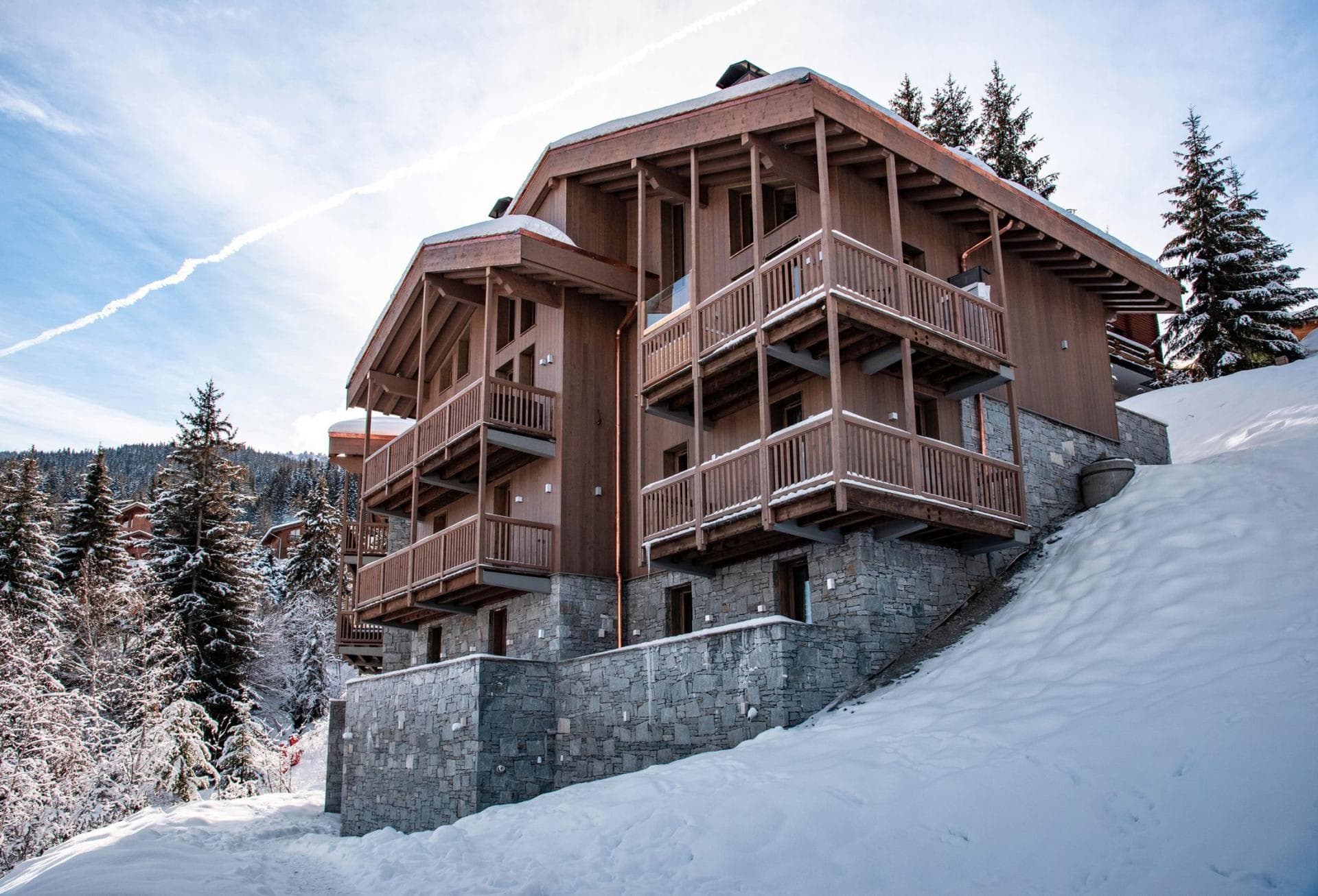 Ski-in/ski-out chalet with multi-level private balconies and stone foundation