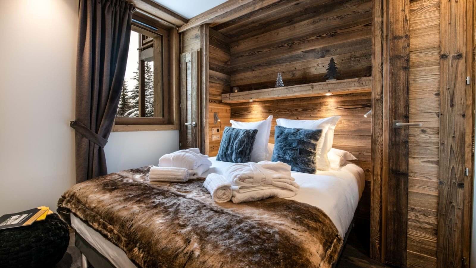 Bedroom with built-in reading lights and views of snow-covered trees