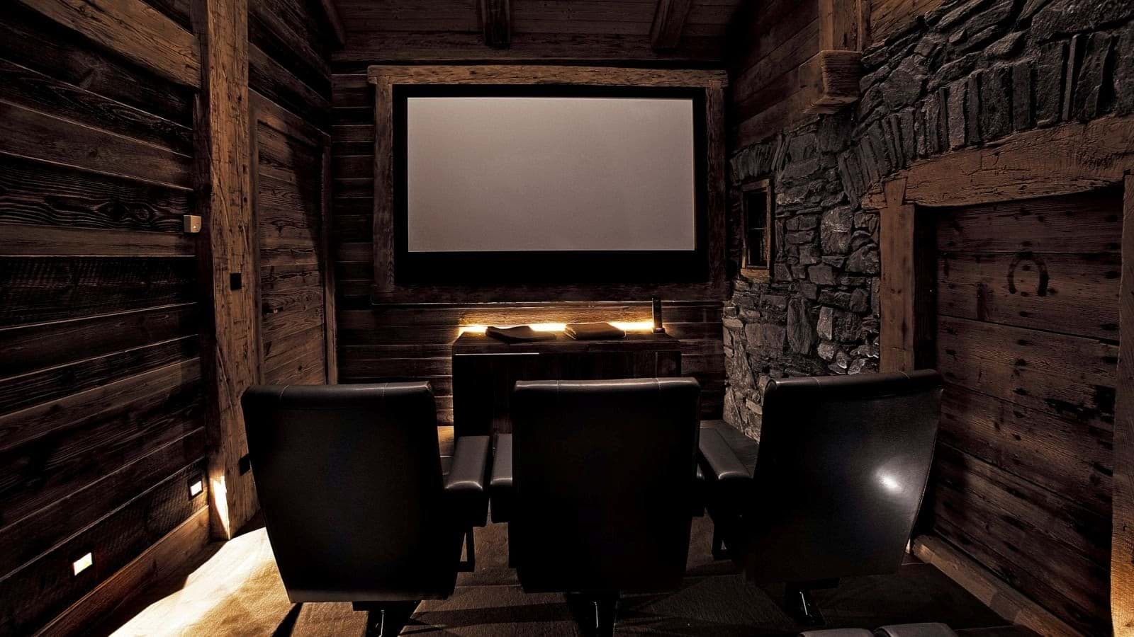 Private cinema room with leather recliners and reclaimed wood walls