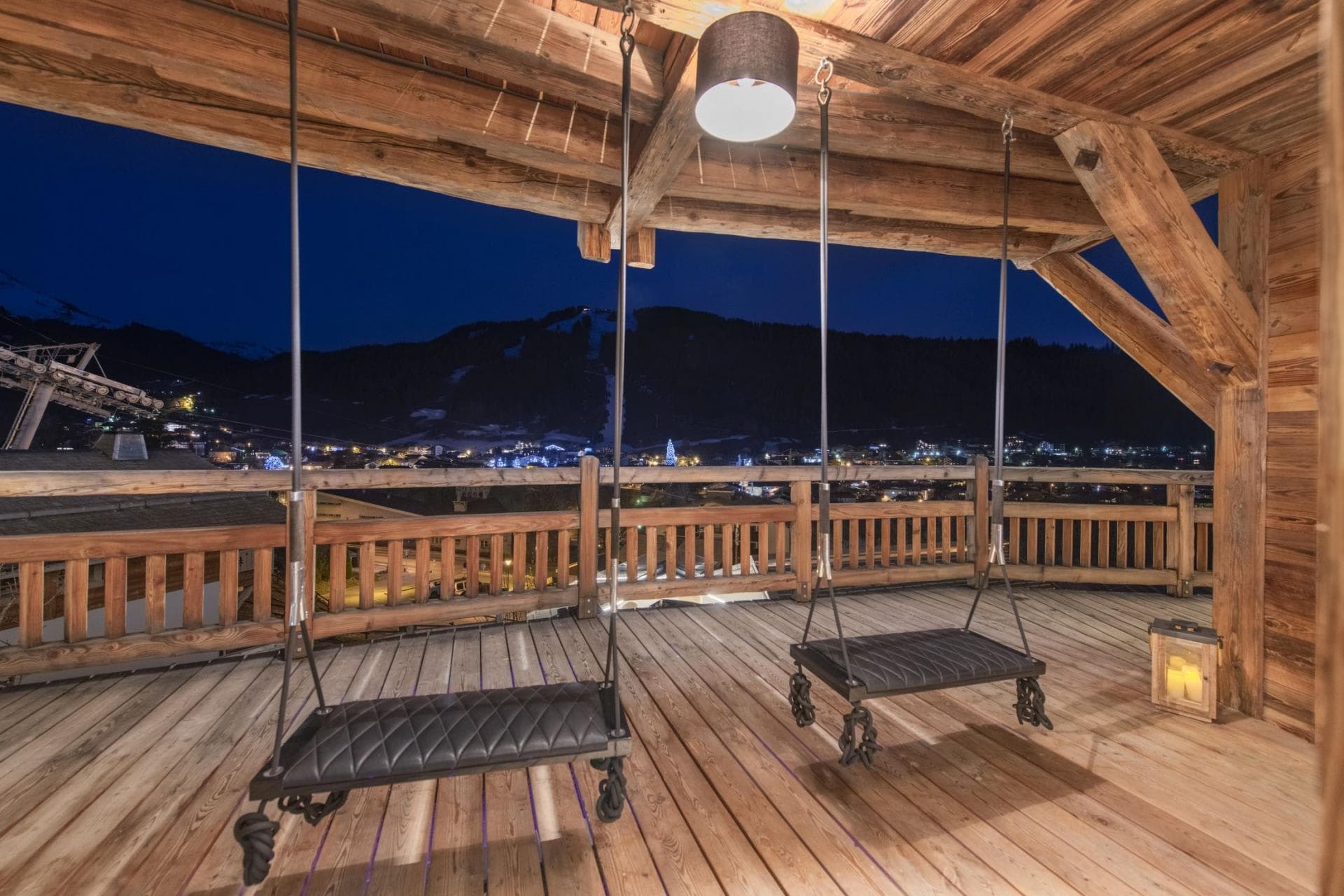 Covered balcony with leather porch swings and village night views