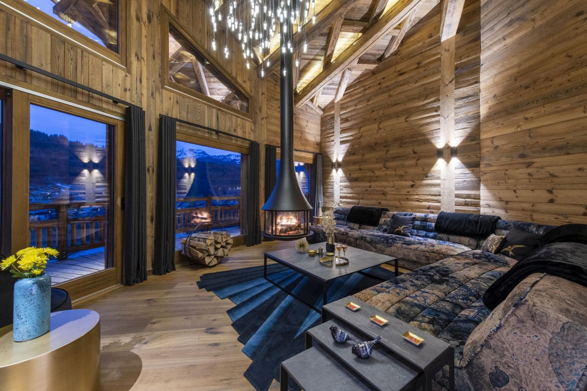 Living area with hanging wood-burning fireplace and mountain-view balcony