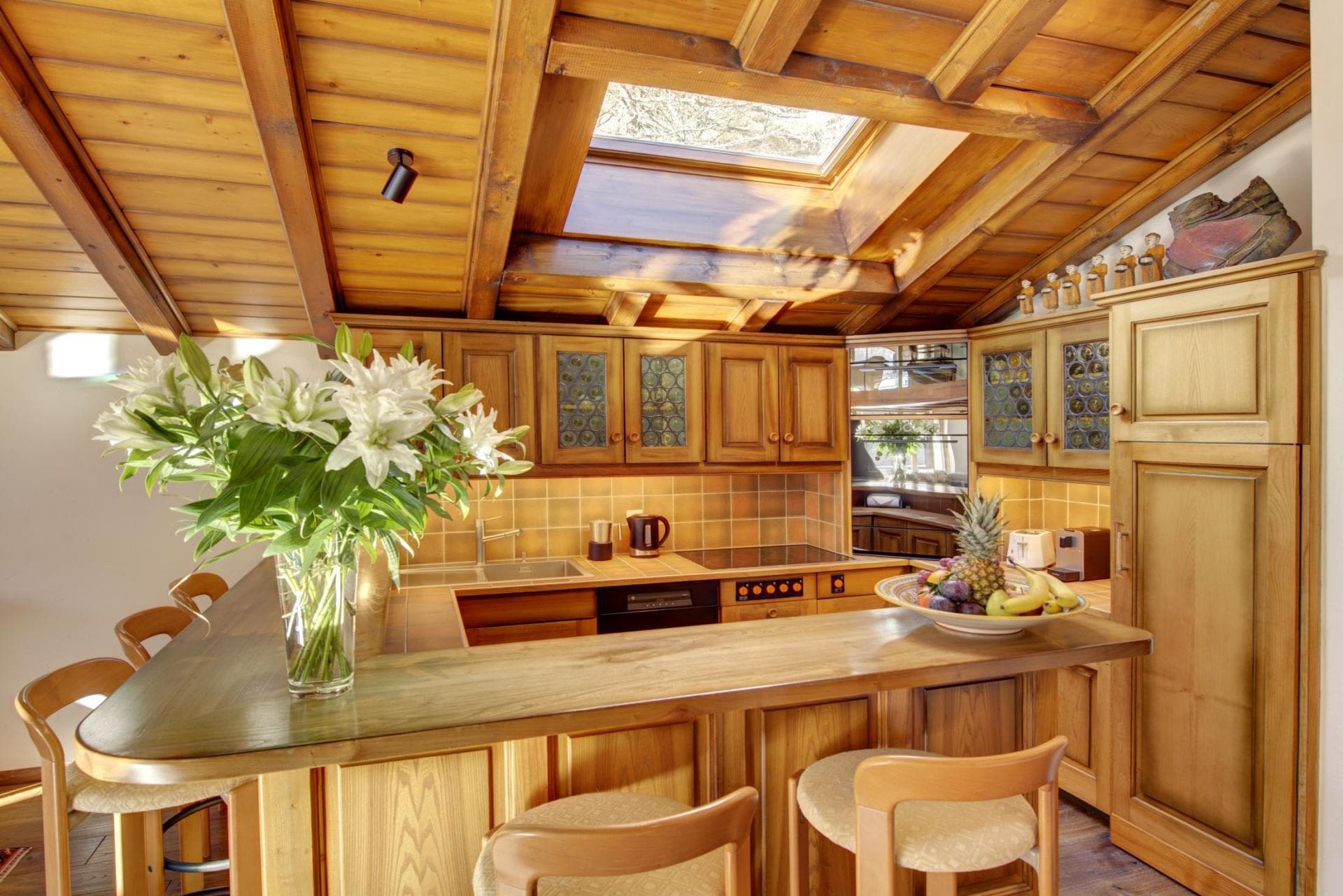 Kitchen with vaulted wood ceiling, skylight, and breakfast bar seating
