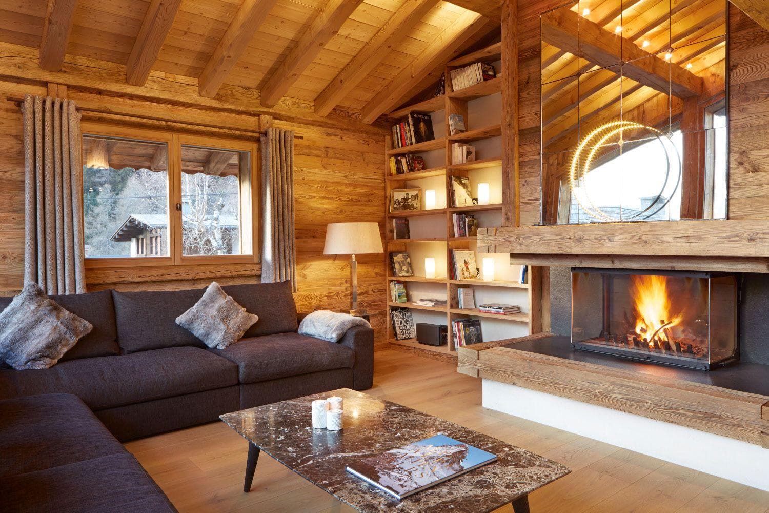 Living room with wood-burning fireplace and backlit library shelving