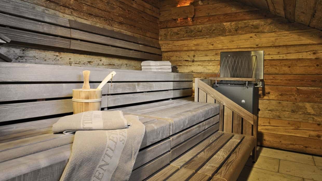Private sauna with tiered bench seating and traditional bucket