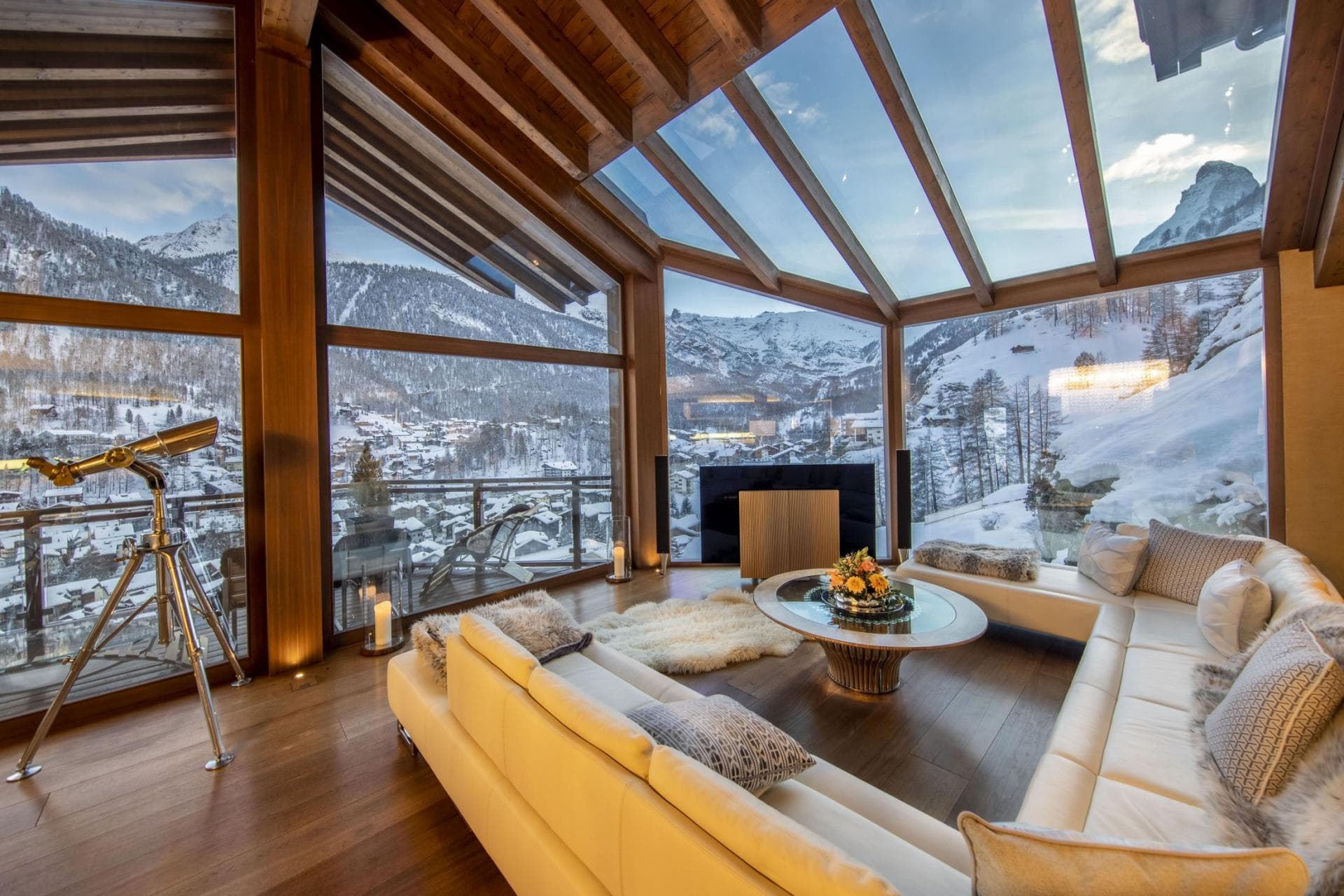 Living room with glass ceiling and telescope; panoramic village and mountain views
