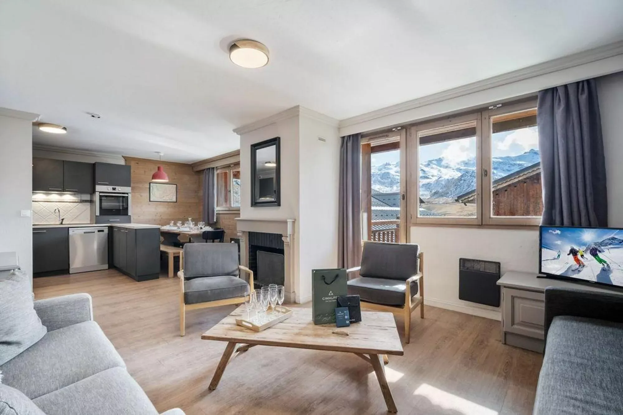 Living room with fireplace, open kitchen and mountain-facing windows