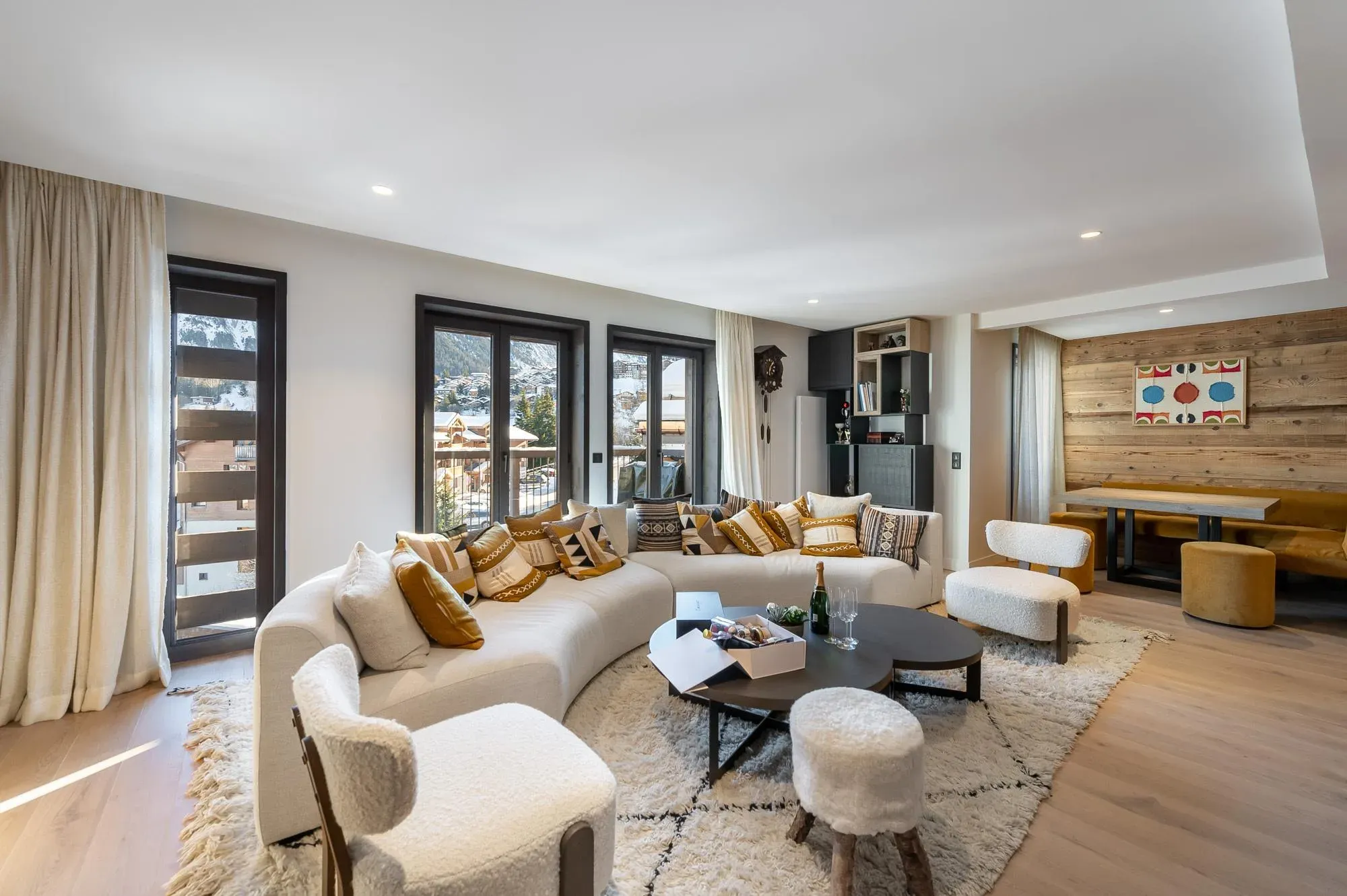 Living room with curved sofa, armchairs and balcony doors