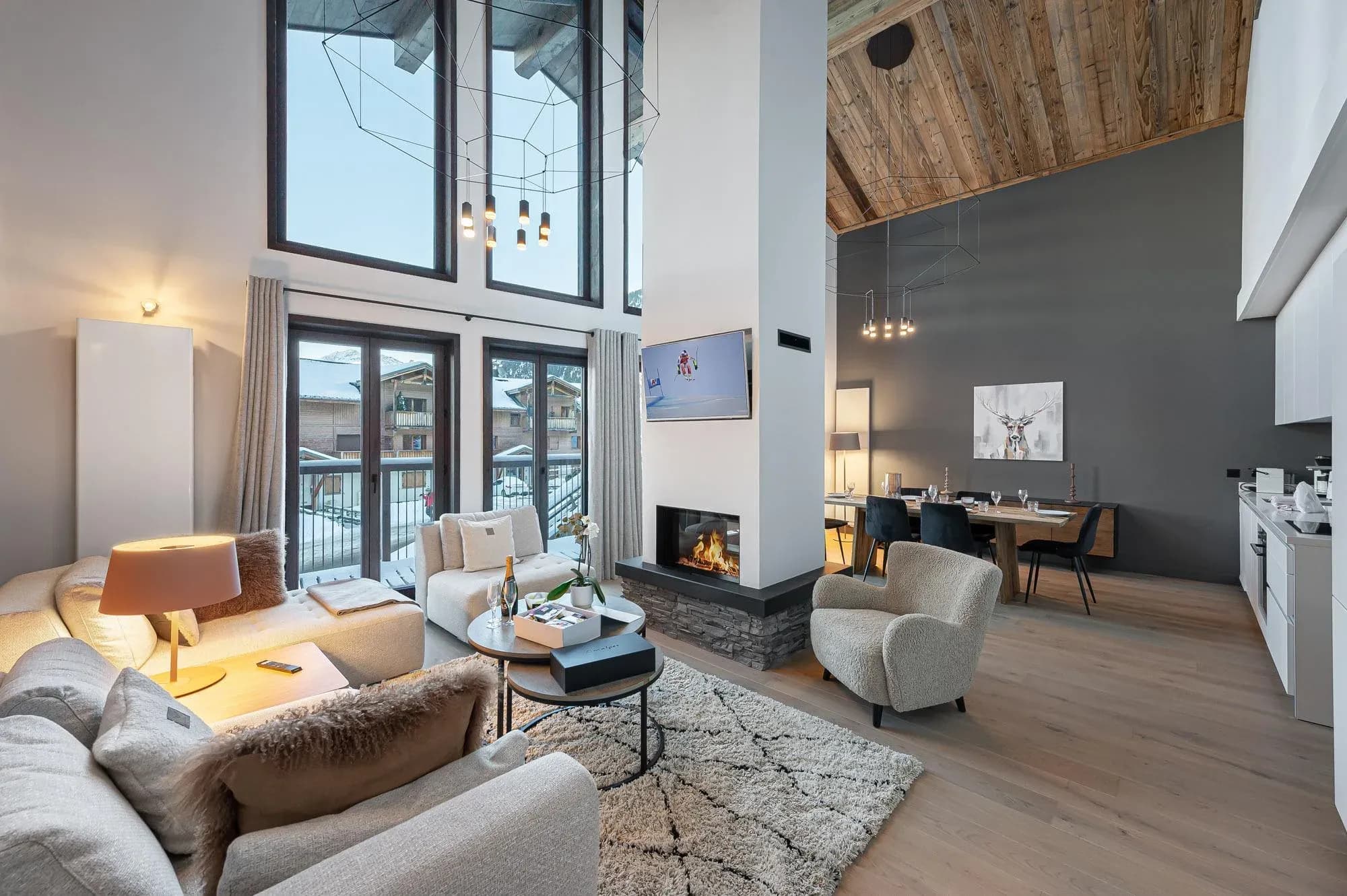 Double-height living area with corner sofa, central fireplace and dining table behind