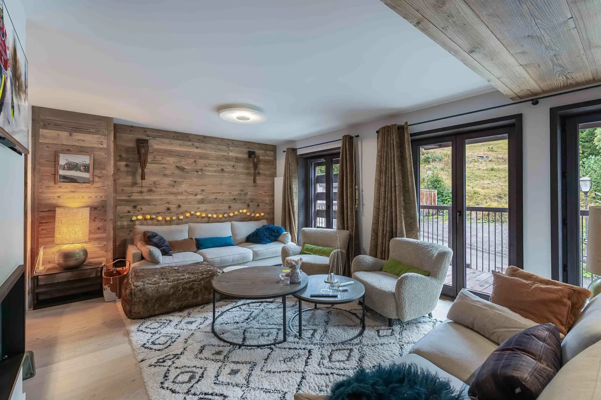 Living room with corner sofa, two armchairs and reclaimed wood wall