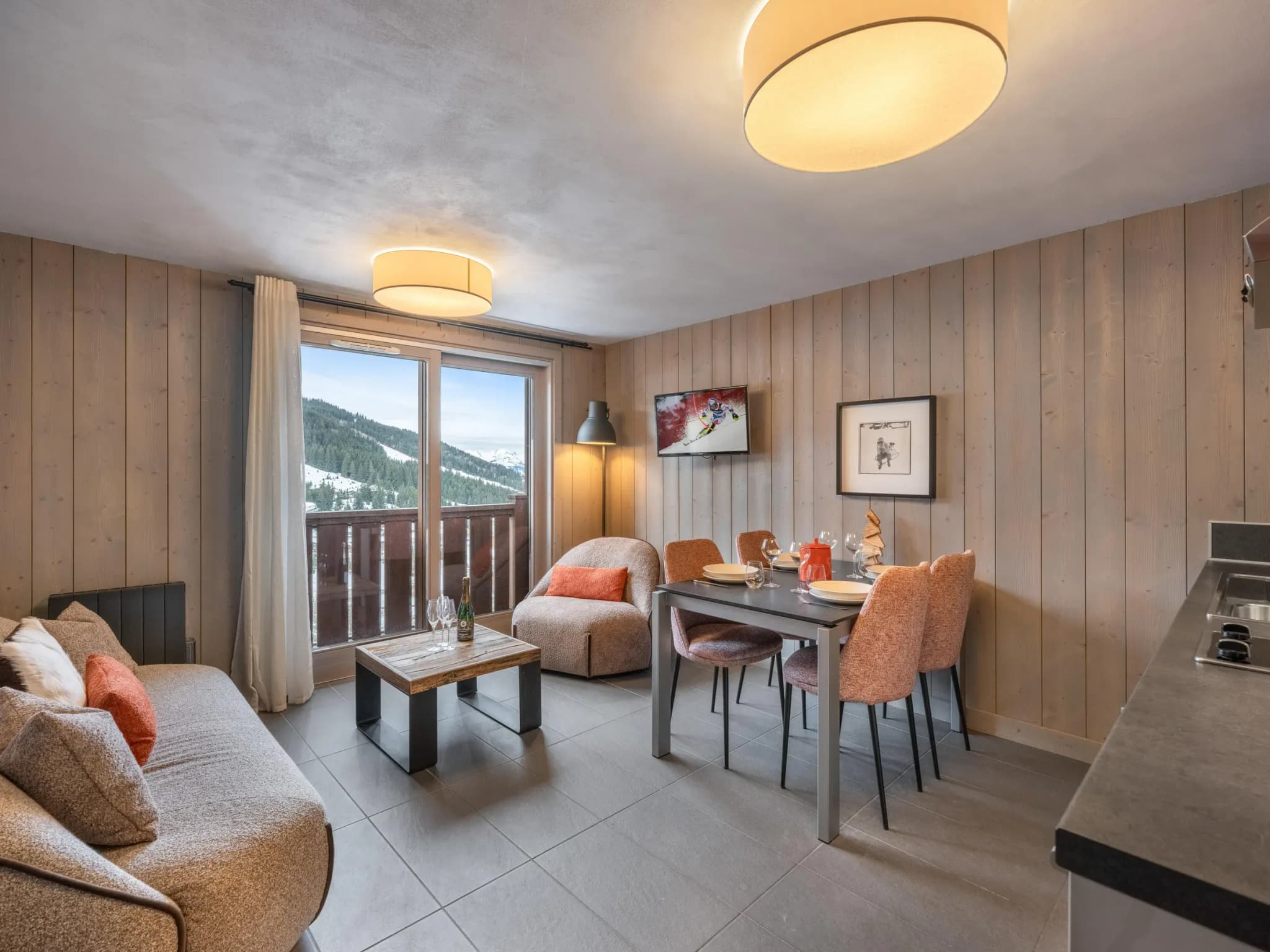 Living area with sofa, armchair and balcony doors facing the mountain view