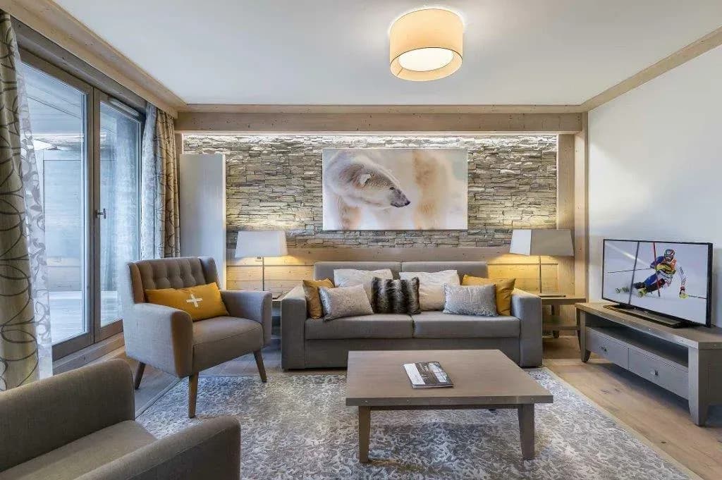 Living room with grey sofa, two armchairs and stone feature wall