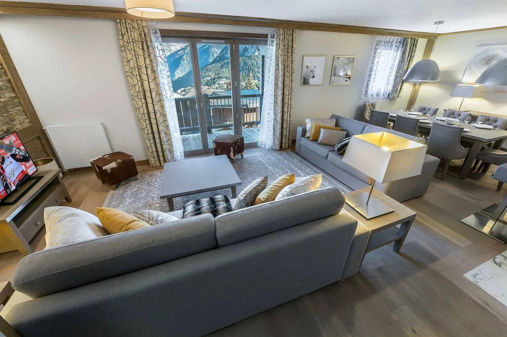 Living room with grey sofas, coffee table and balcony doors facing the mountains