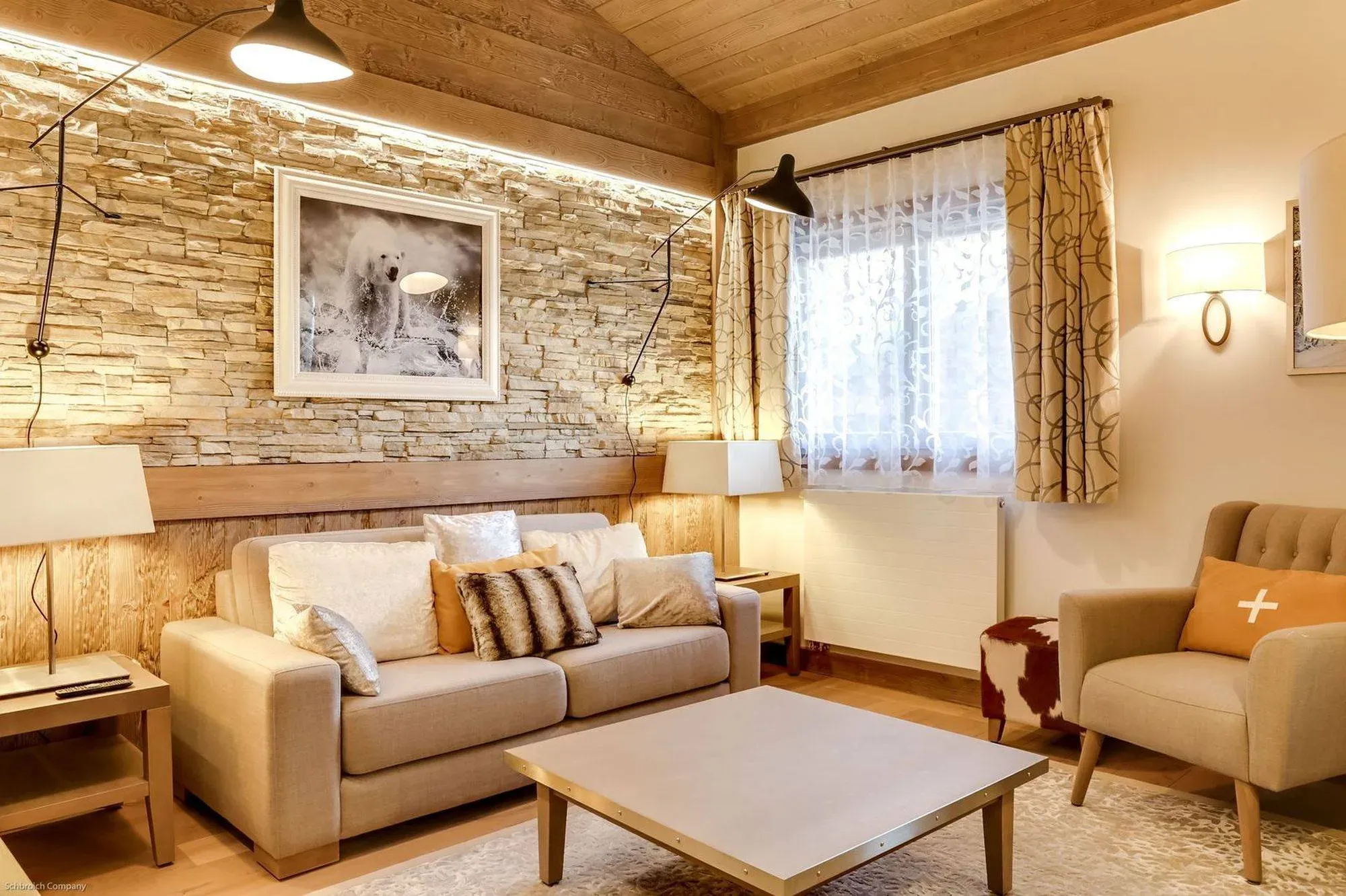 Living room with beige sofa, armchair, coffee table and stone feature wall