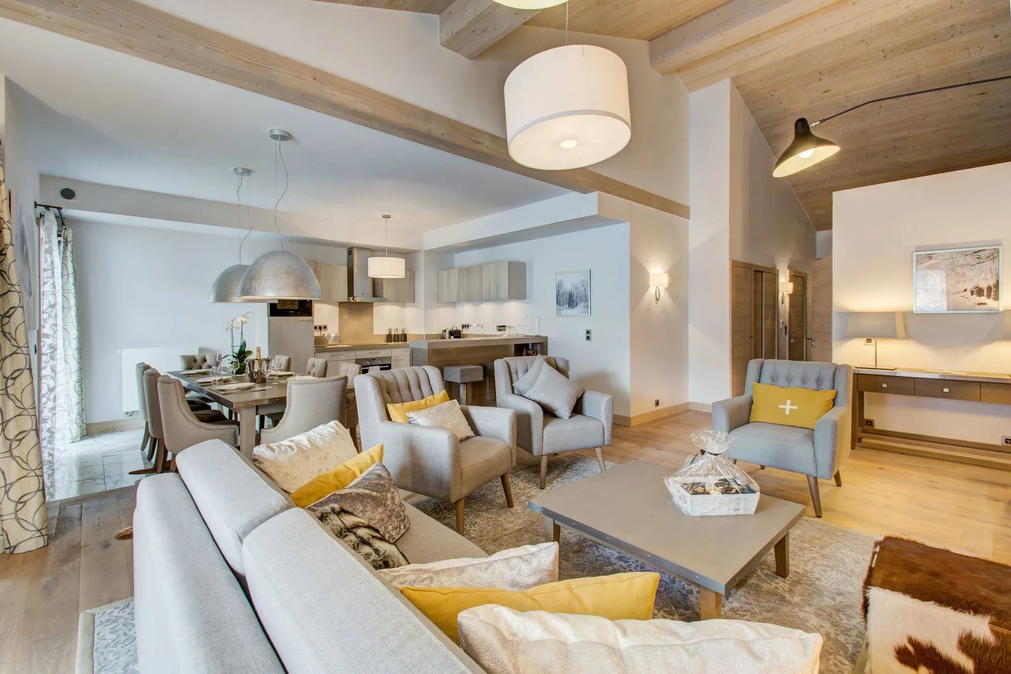 Open-plan living area with sofa, armchairs and dining table beside the kitchen