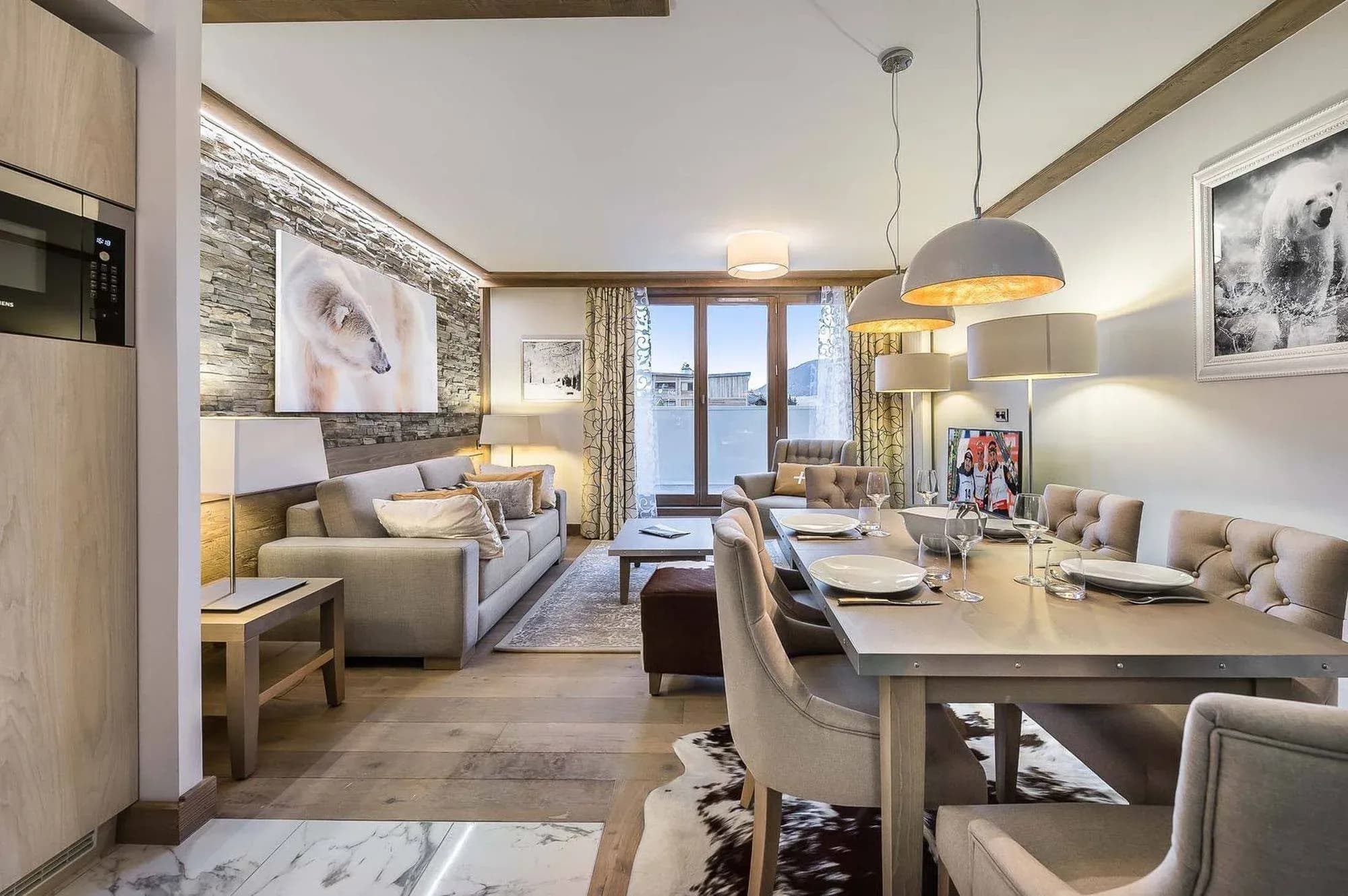 Living and dining area with grey sofa, stone feature wall and table for six