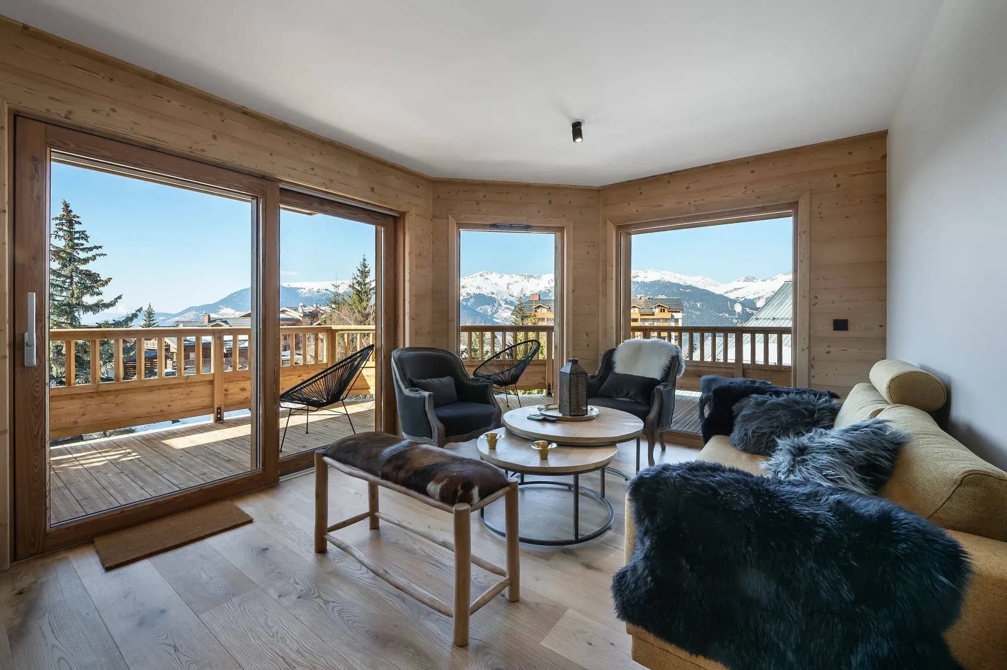 Living room with sofa, armchairs and balcony doors facing the mountains