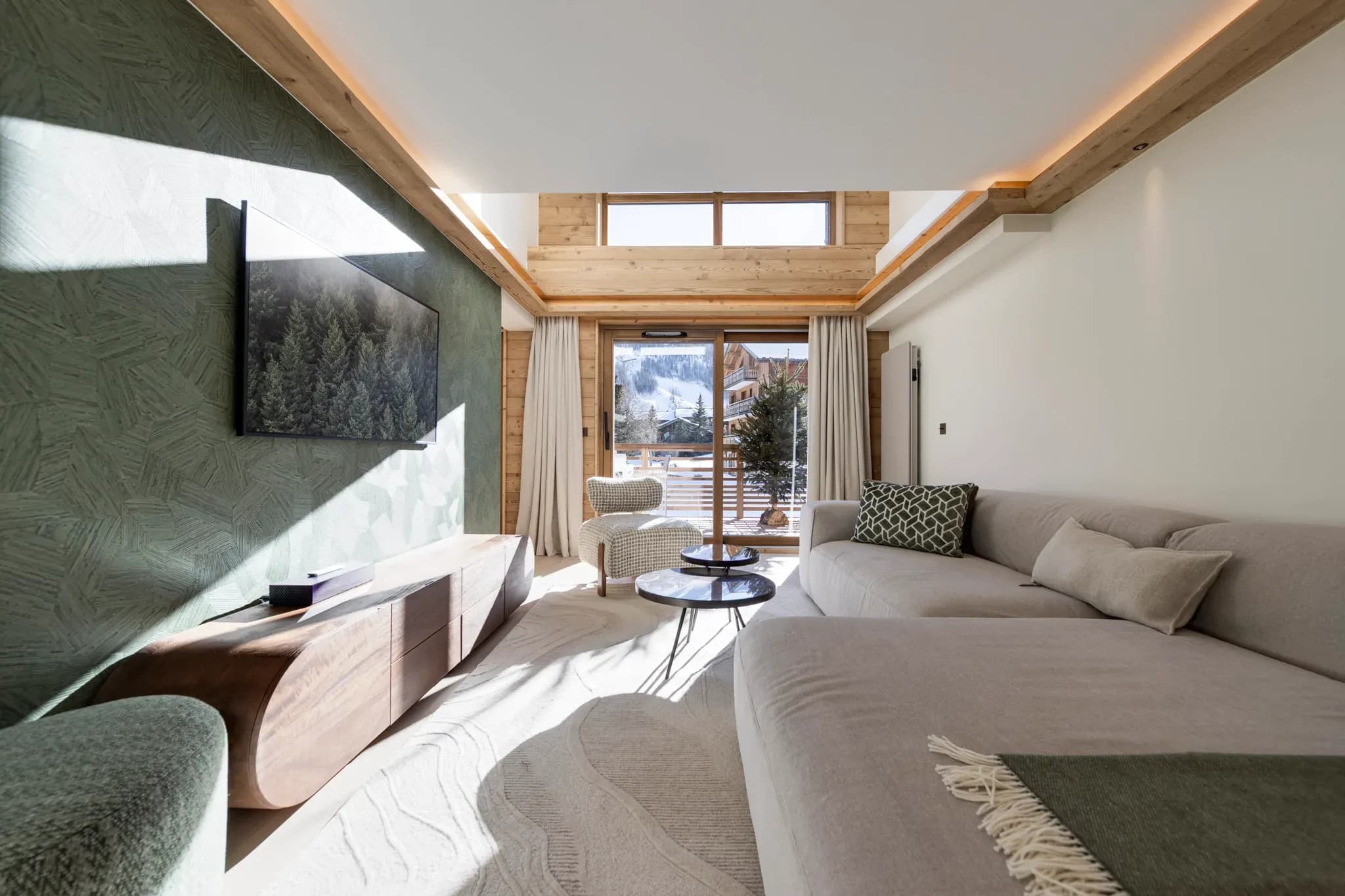 Living room with grey corner sofa, wall-mounted TV and balcony doors