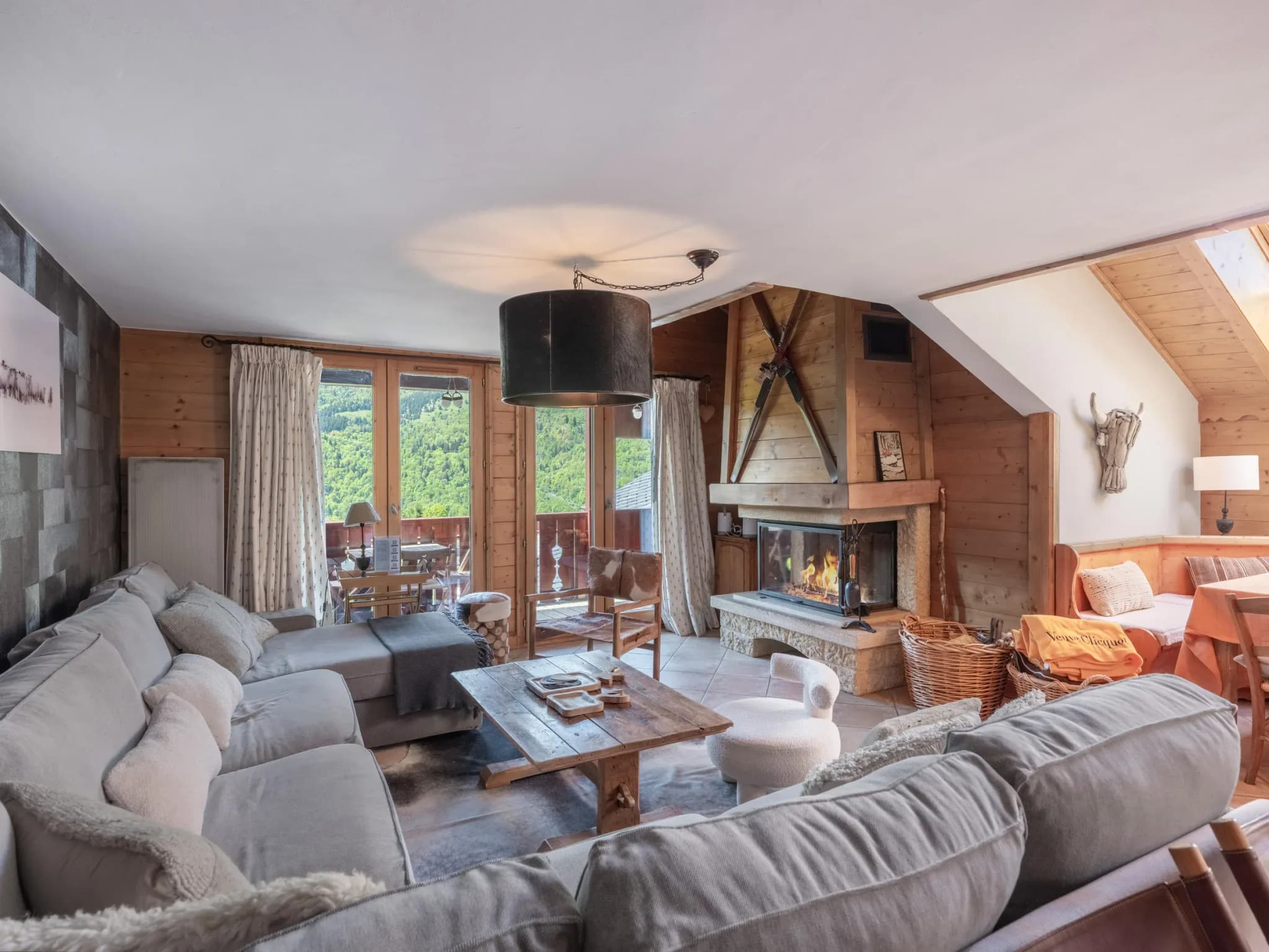 Living room with grey sofas, wood-burning fireplace and glass doors to the balcony