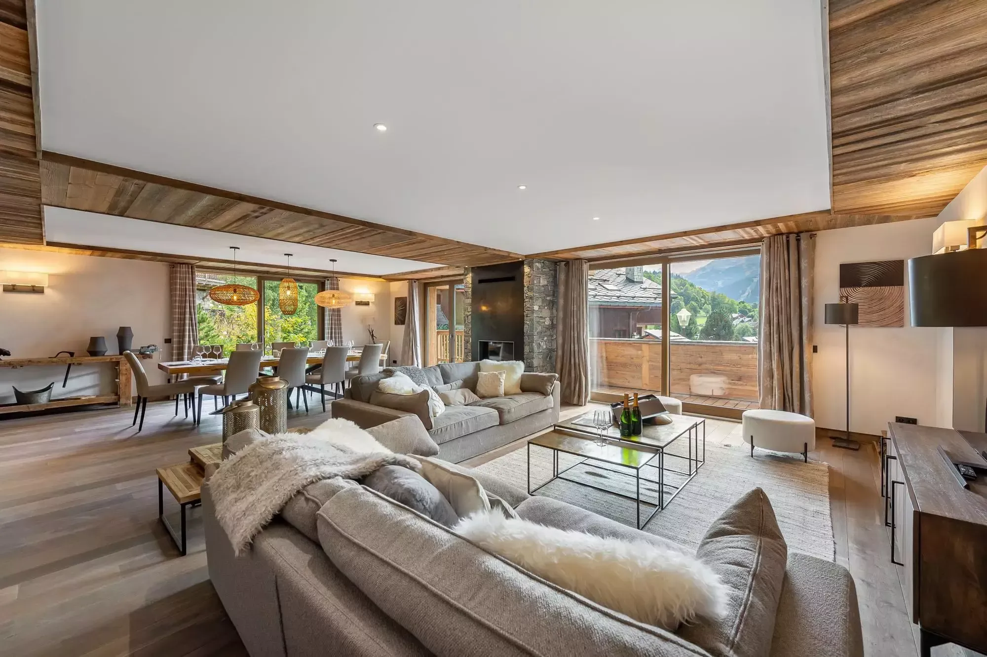 Open-plan living room with balcony access and an Alpine outlook