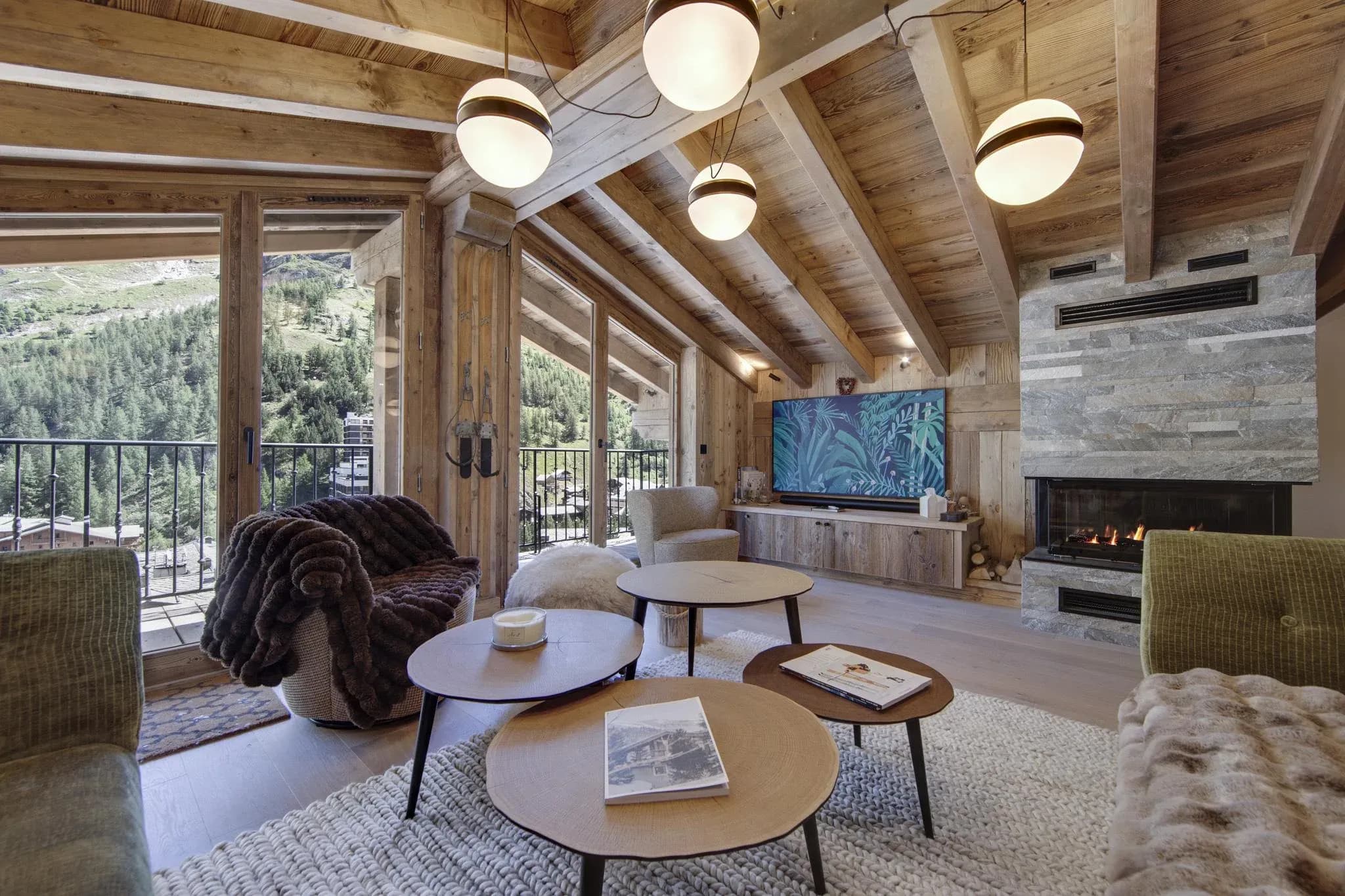 Living room with gas fireplace, round coffee tables and balcony doors facing the valley
