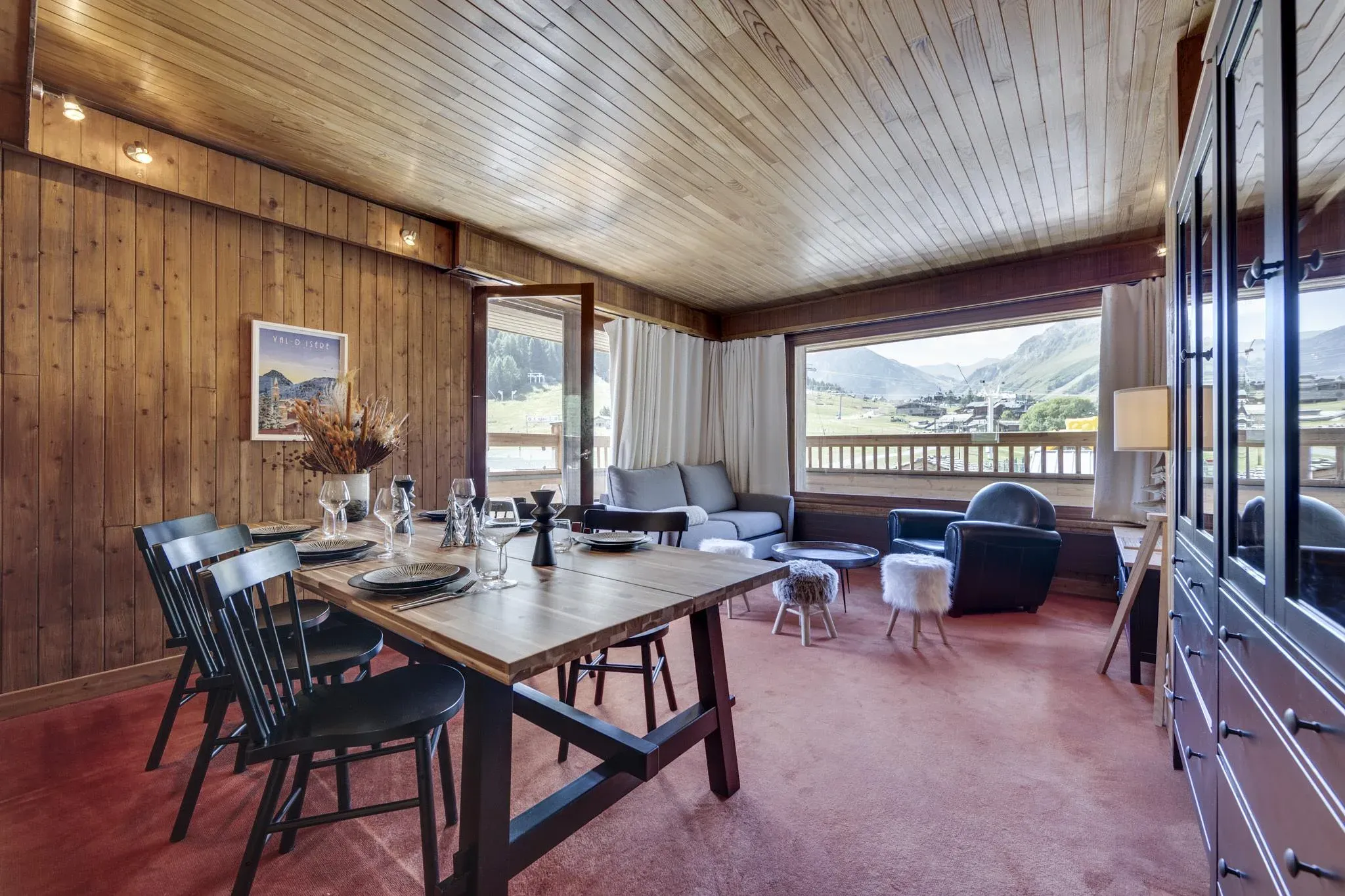 Dining area with wooden table, black chairs and mountain view window