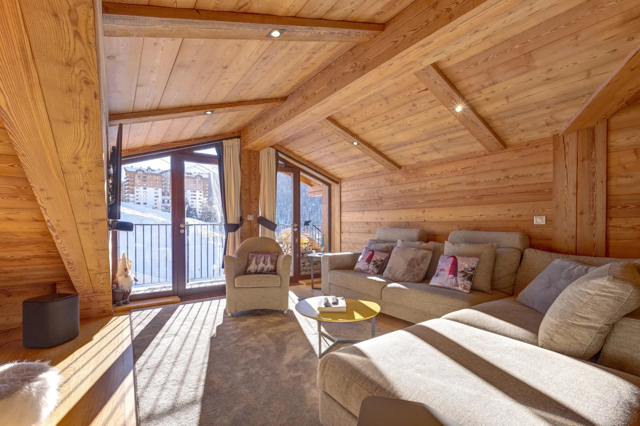 Lounge with corner sofa, armchair and balcony doors facing the slopes