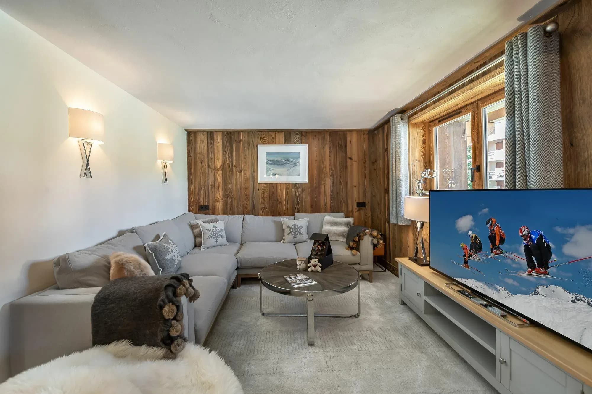 Living room with grey corner sofa, glass coffee table and wall-mounted TV on a wide unit