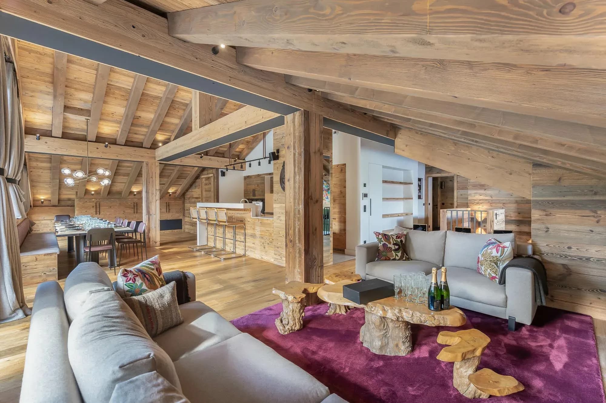 Living room with two grey sofas, purple rug and open dining area behind