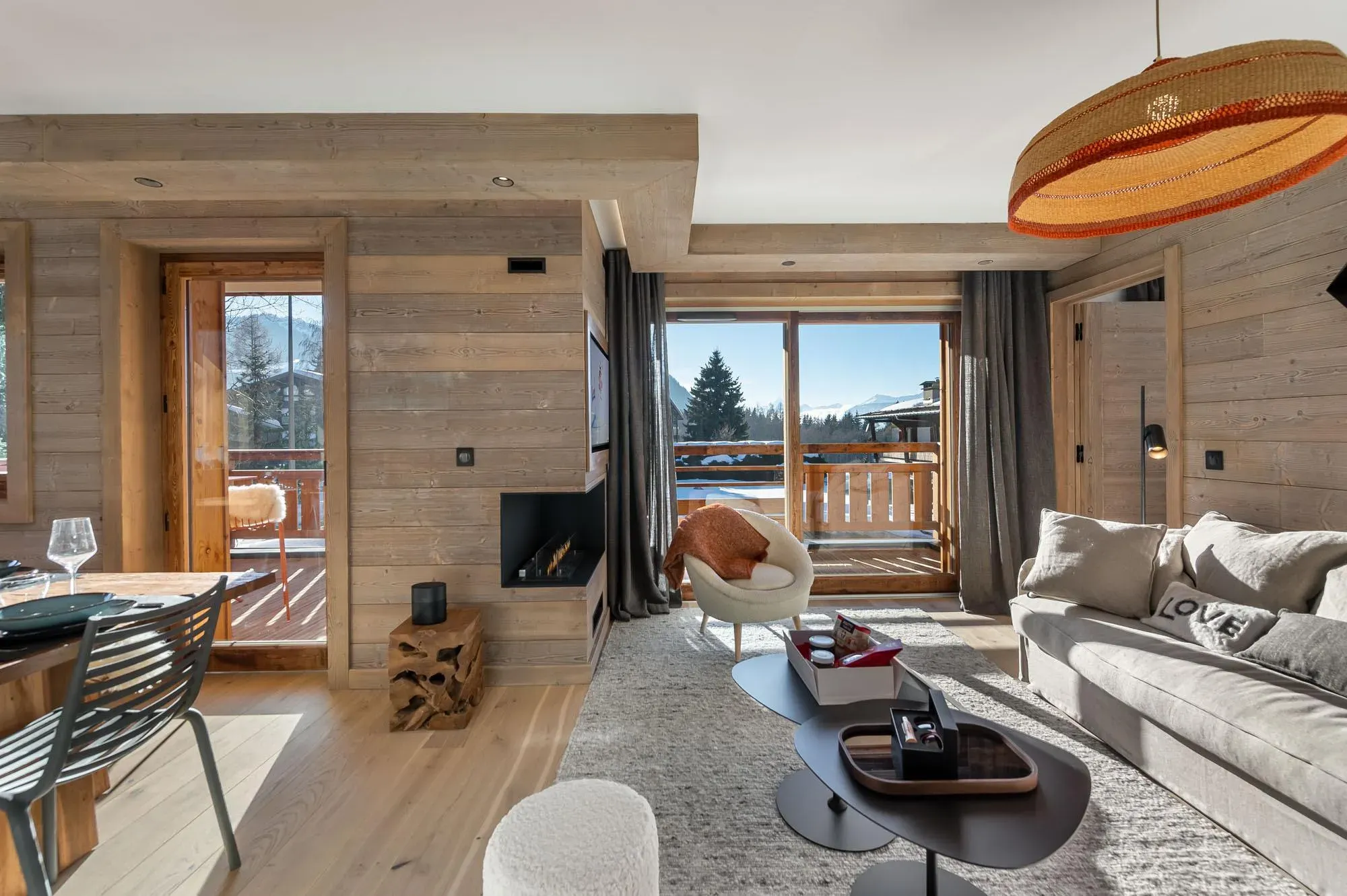 Lounge with ethanol fireplace, sofa and balcony doors opening to mountain views