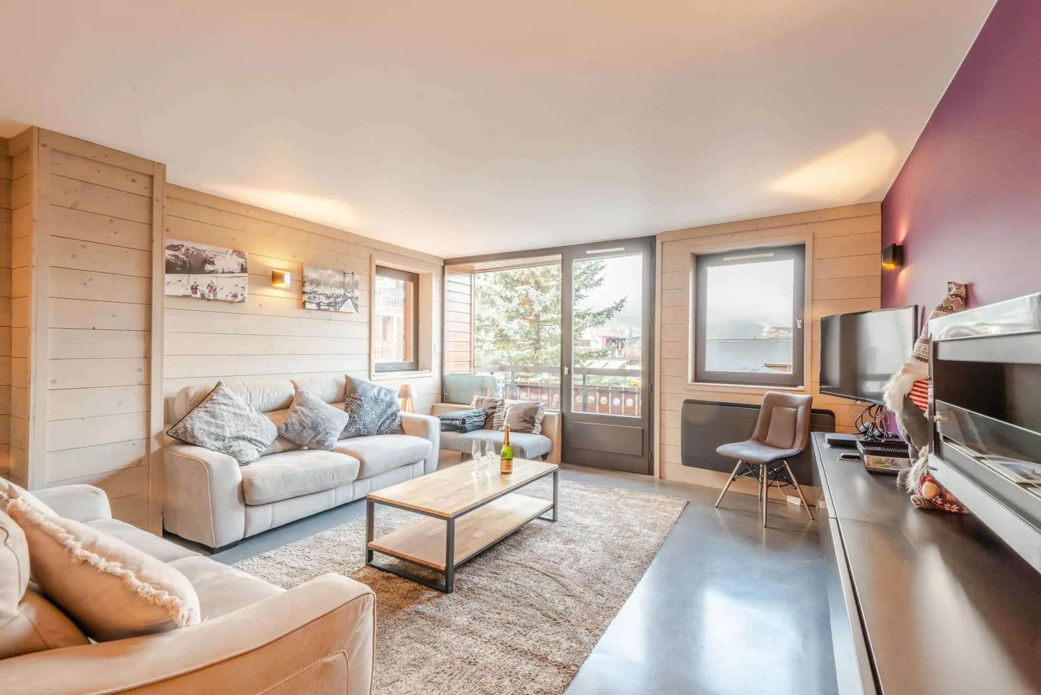 Living room with two sofas, coffee table, wall-mounted TV and balcony door