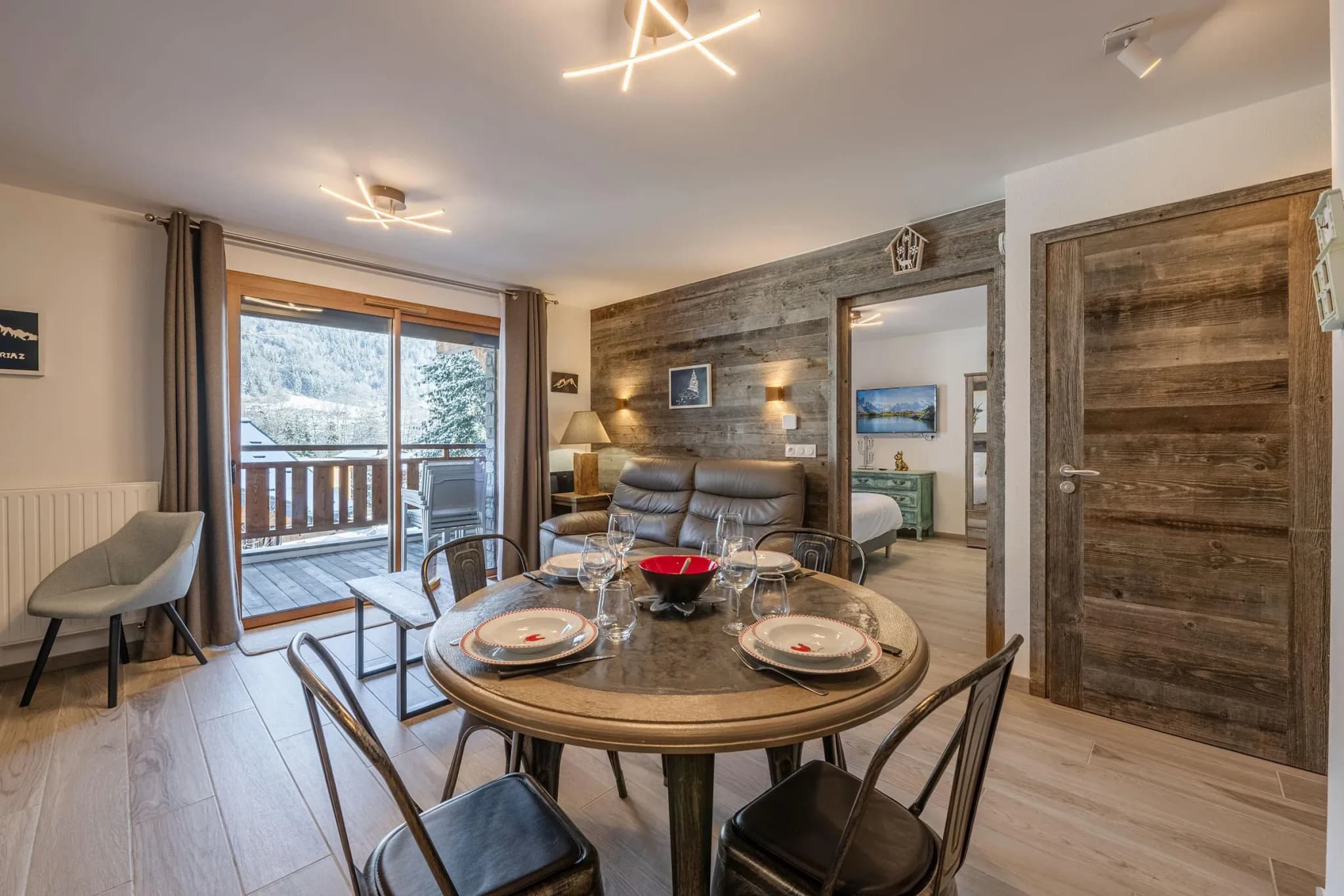 Round dining table set for four with metal chairs and balcony access
