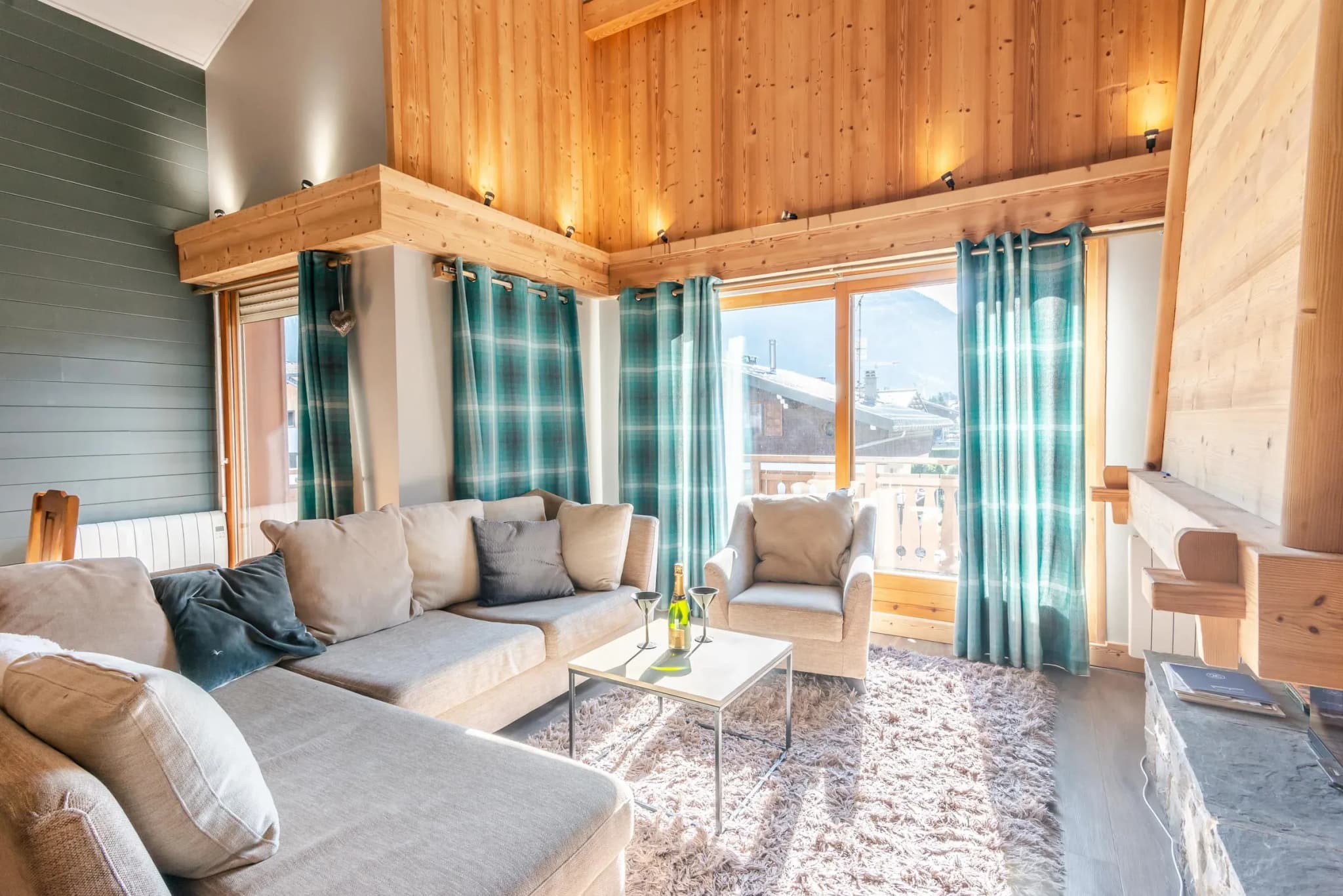 Living room with corner sofa, armchair and balcony doors with mountain view