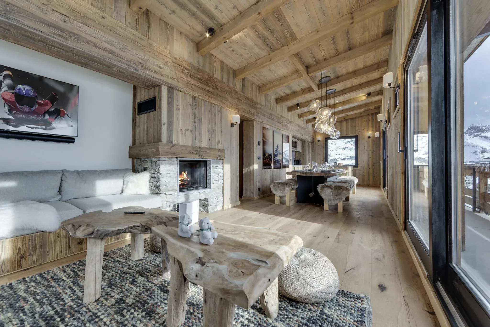 Living room with corner sofa, stone fireplace and driftwood coffee tables