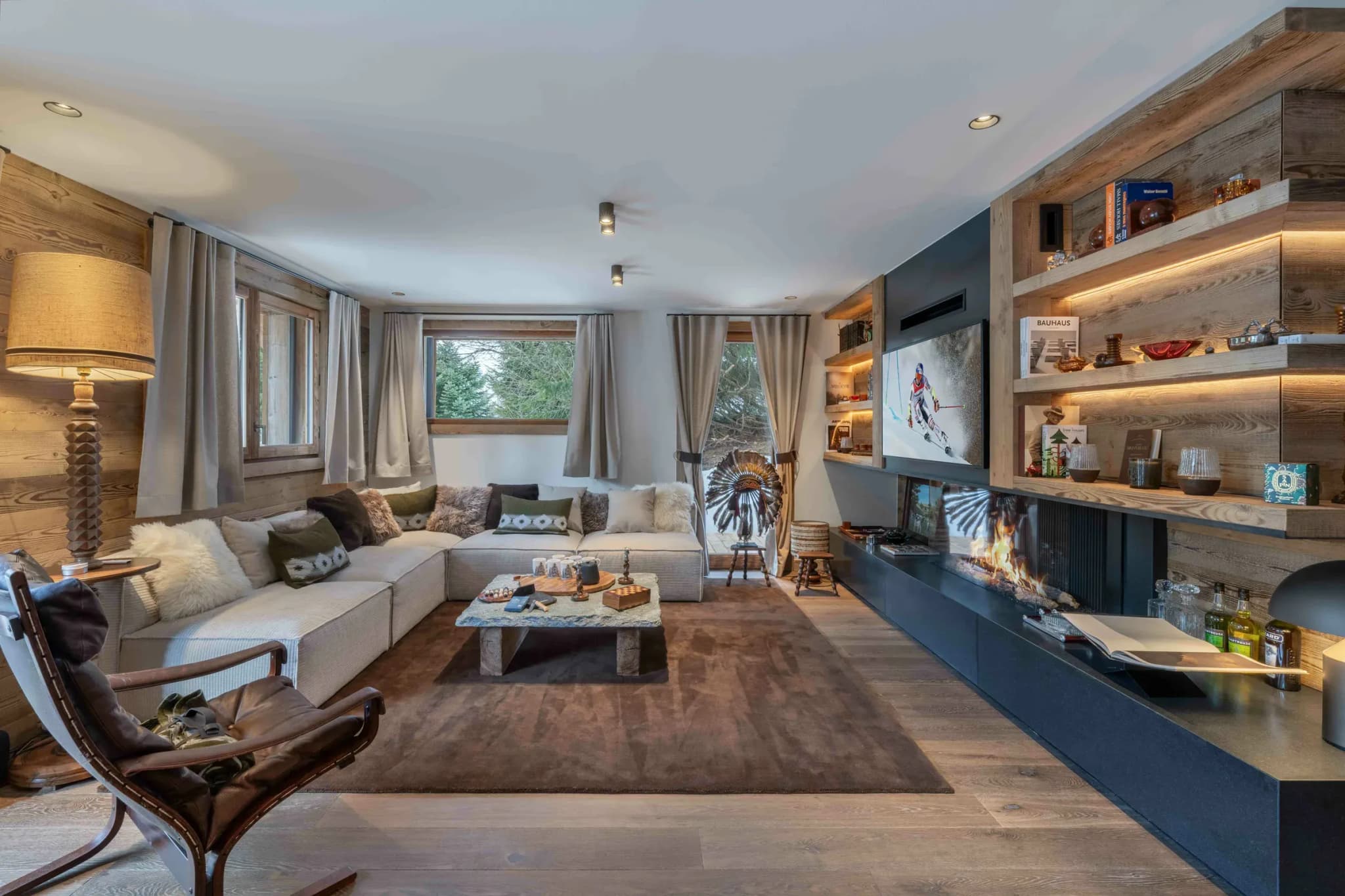 Living room with corner sofa, gas fireplace and wood-clad shelving