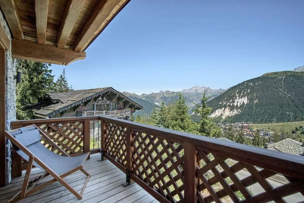 Balcony with deck chair and view over rooftops to mountains