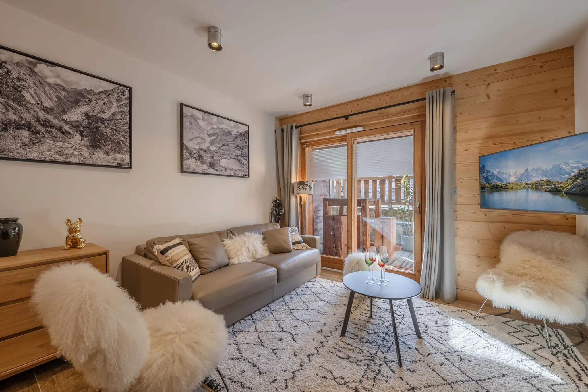 Lounge with grey leather sofa, sheepskin chairs and sliding door to balcony