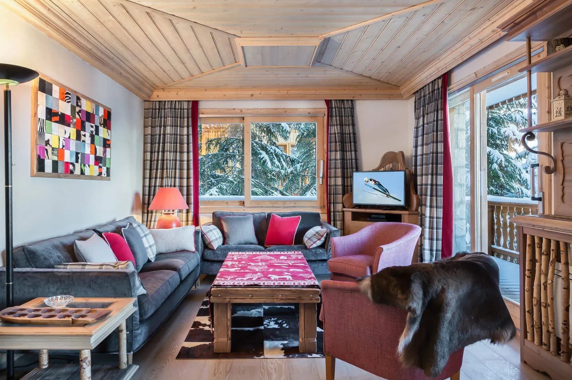 Living room with grey sofa, two armchairs, wooden coffee table and TV