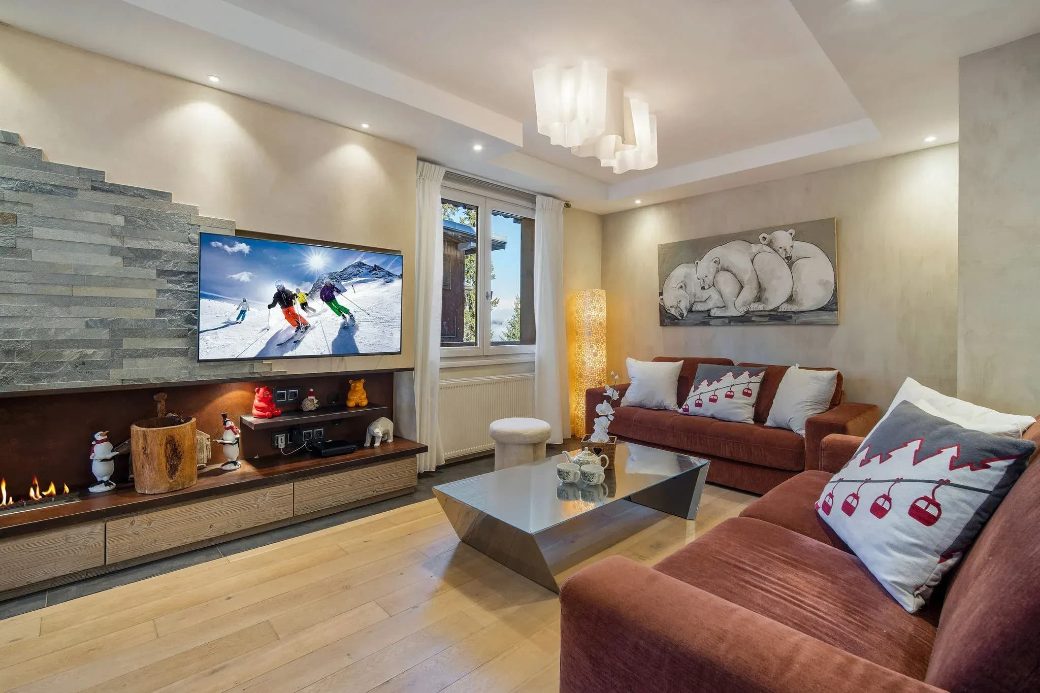 Living room with wall-mounted TV, gas fireplace and two velvet sofas