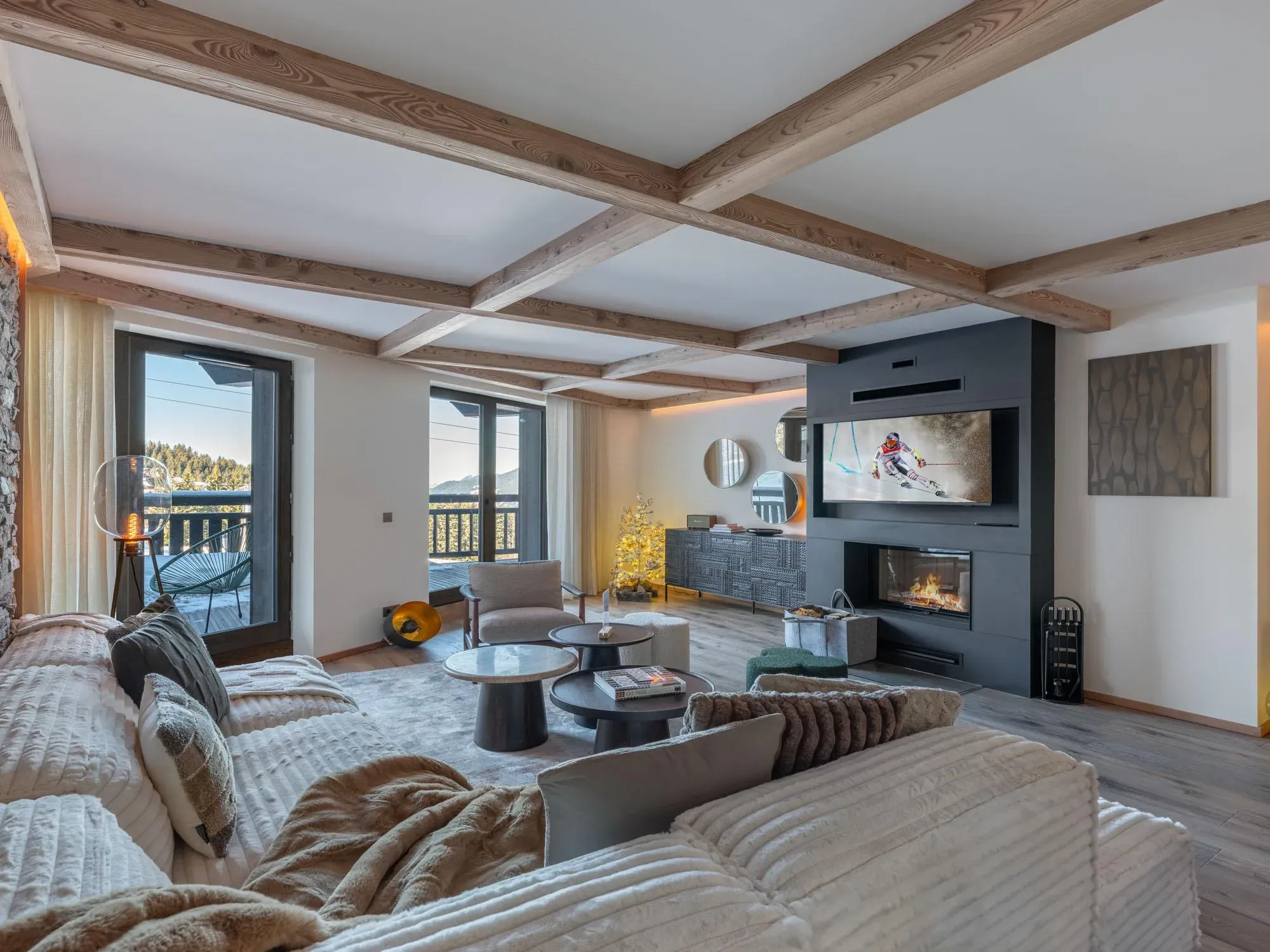 Living room with corner sofa, wood-burning fireplace and balcony doors