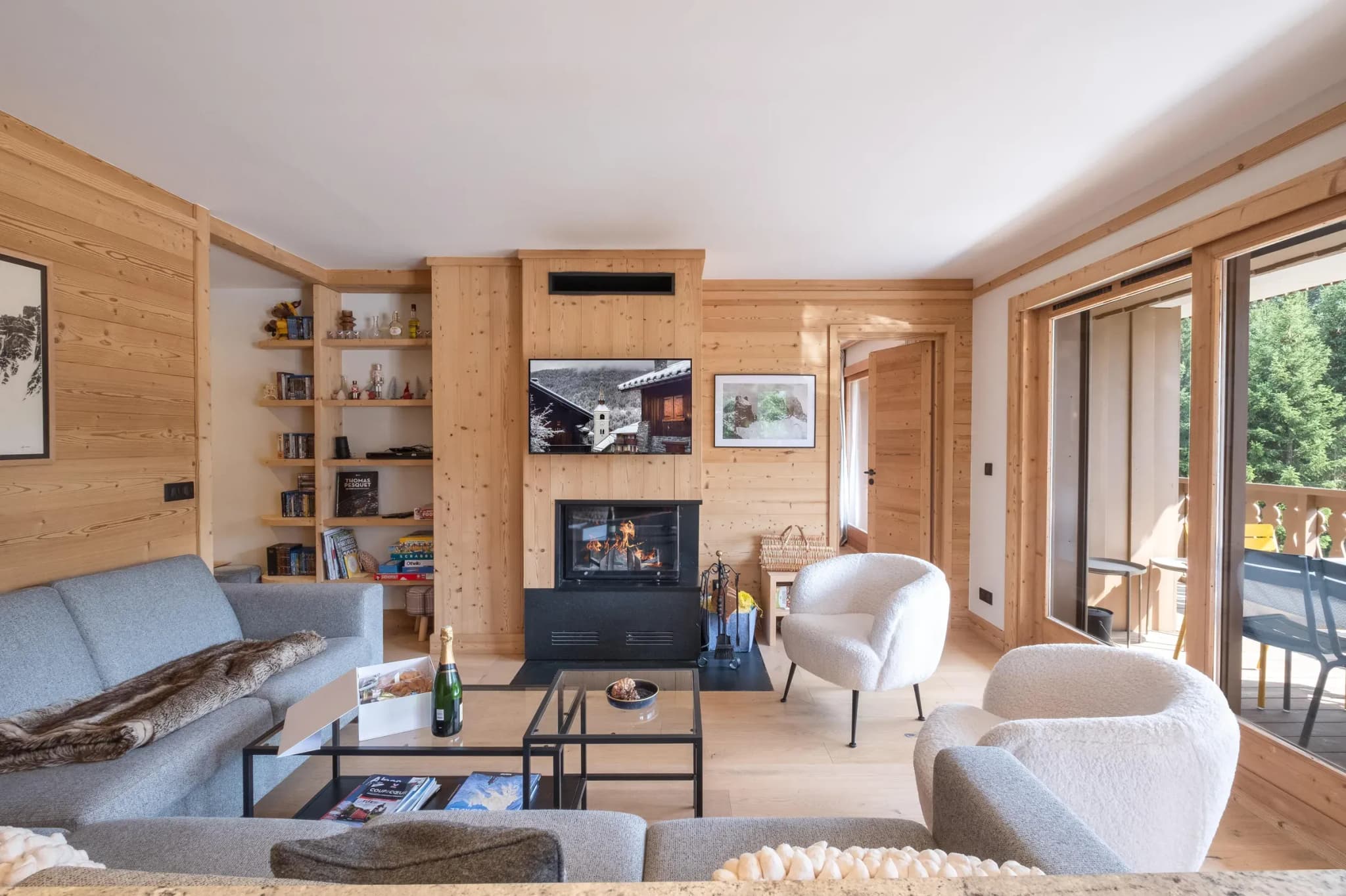 Living room with wood-burning stove, dual seating areas, and glass doors to deck