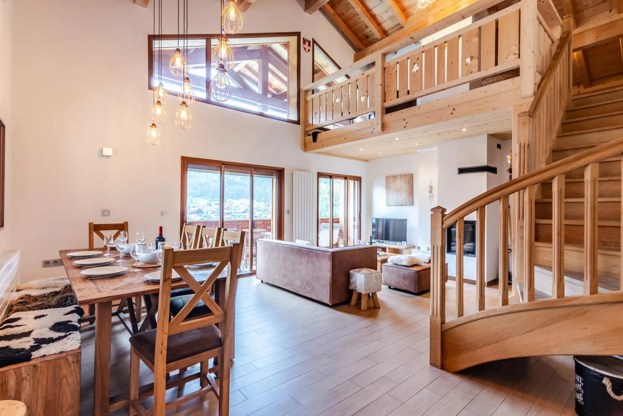 Open-plan living and dining area with spiral staircase and mezzanine